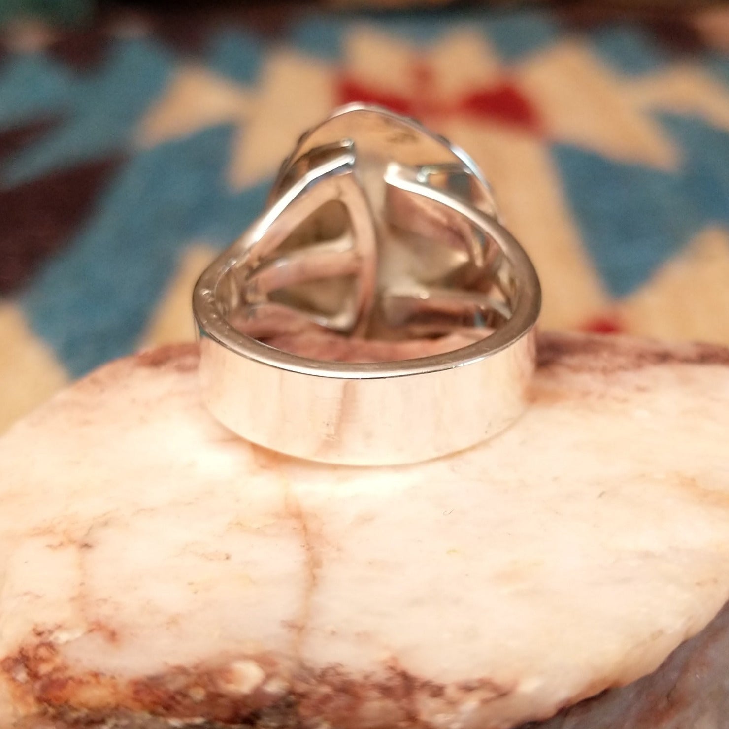 Sterling silver ring with Arizona blue opal set in the bezel, framed by the ornate setting and features vibrant green and red firing.