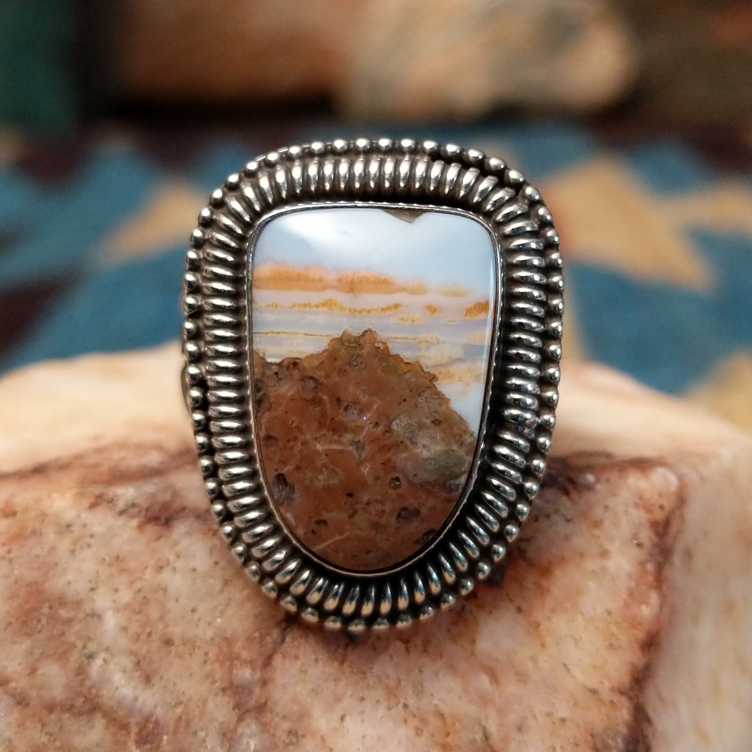 Sterling silver ring with Arizona blue opal set in the large bezel, framed by ribbed silverwork.