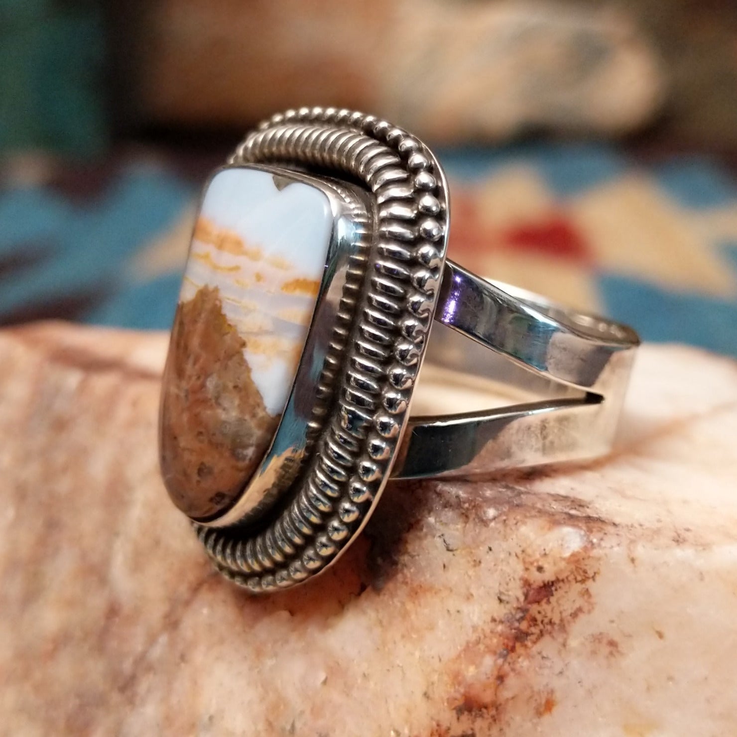 Sterling silver ring with Arizona blue opal set in the large bezel, framed by ribbed silverwork.