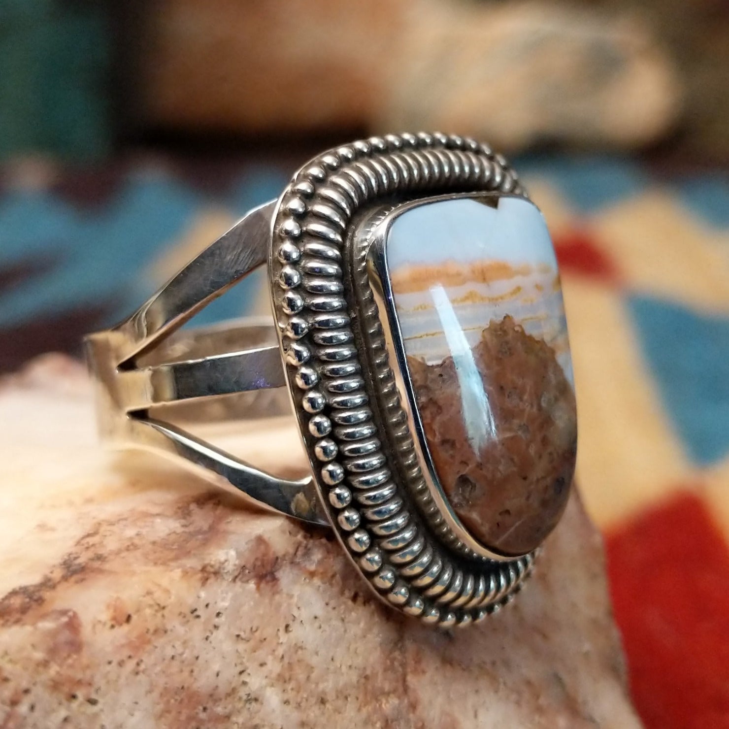 Sterling silver ring with Arizona blue opal set in the large bezel, framed by ribbed silverwork.
