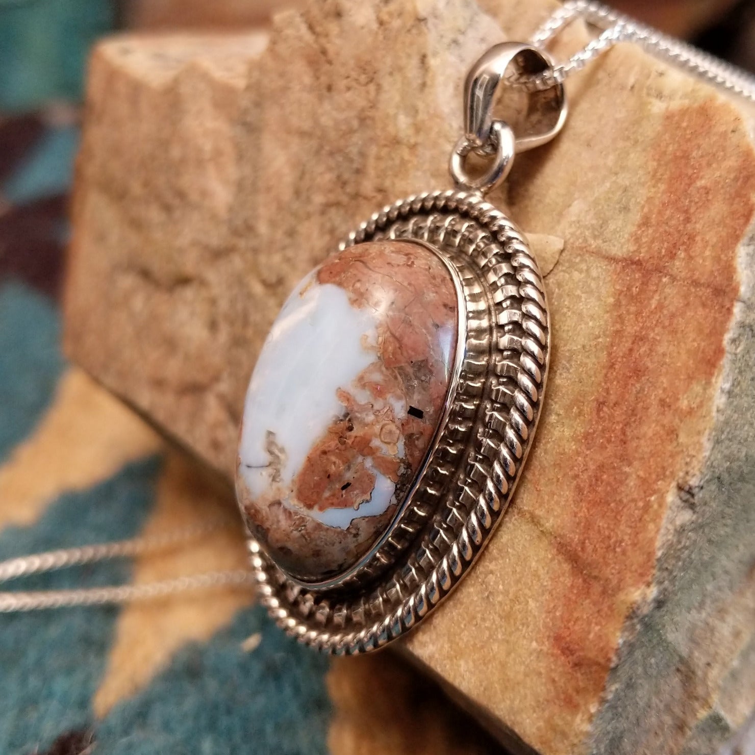 Sterling silver pendant with Arizona blue opal set in the oval bezel, framed by ornate silverwork.