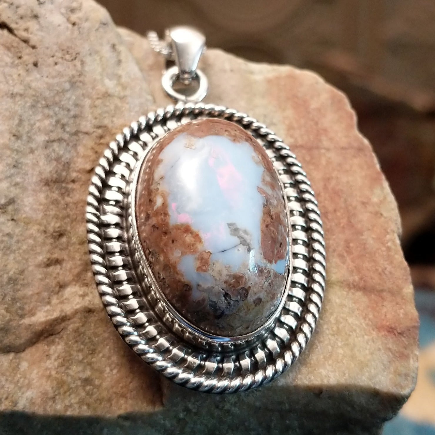 Sterling silver pendant with Arizona blue opal set in the oval bezel, framed by ornate silverwork.