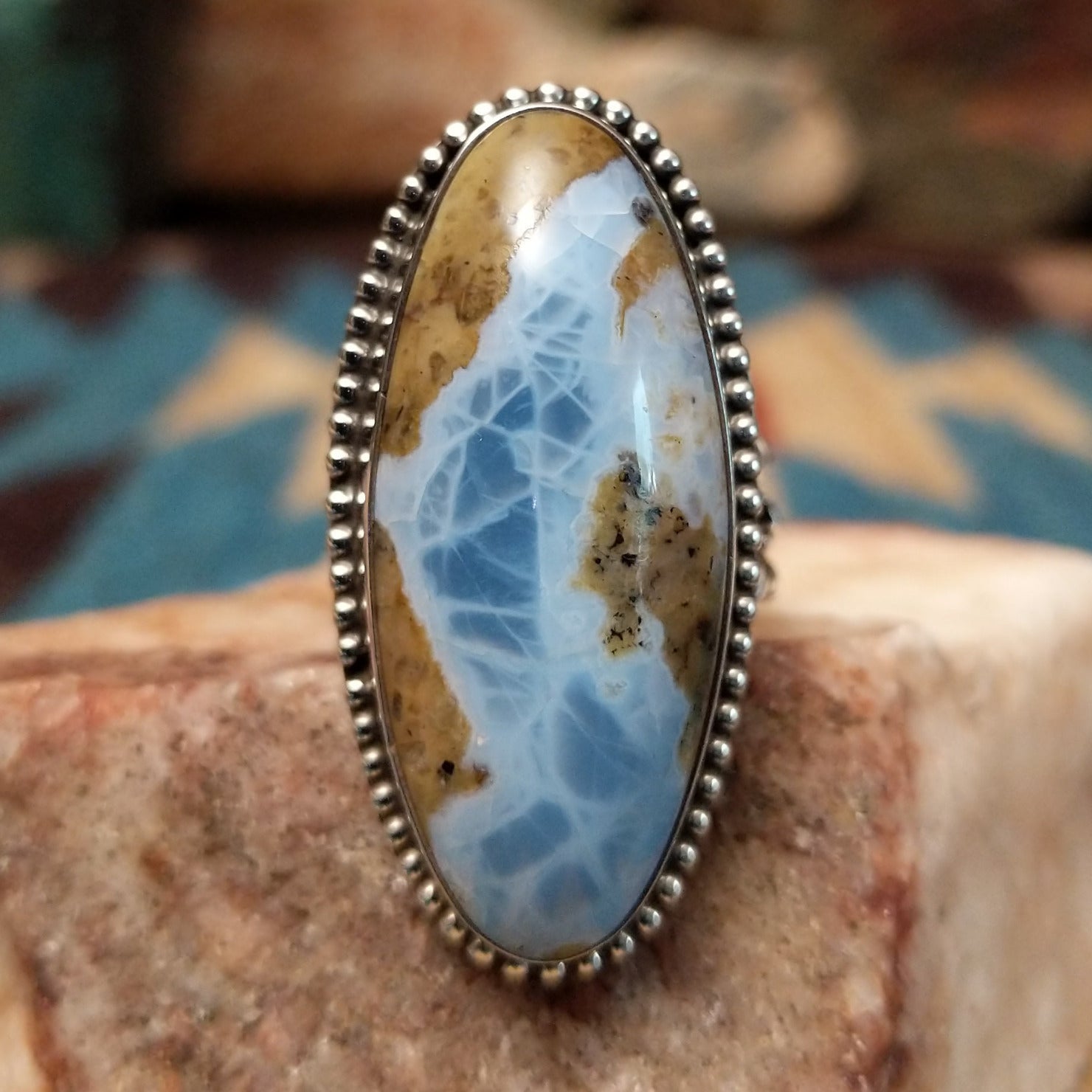 Sterling silver ring with Arizona blue opal set in the large oval bezel, framed by dotted accents.