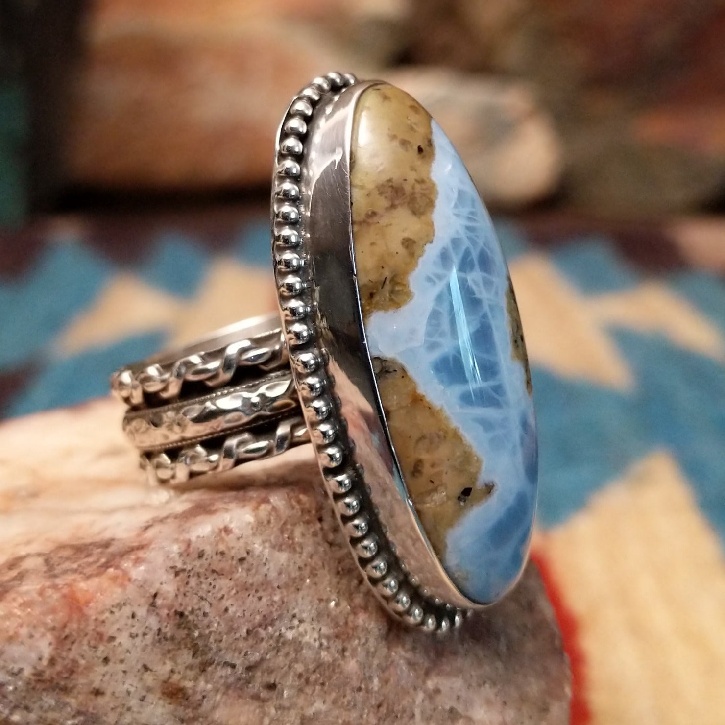 Sterling silver ring with Arizona blue opal set in the large oval bezel, framed by dotted accents.