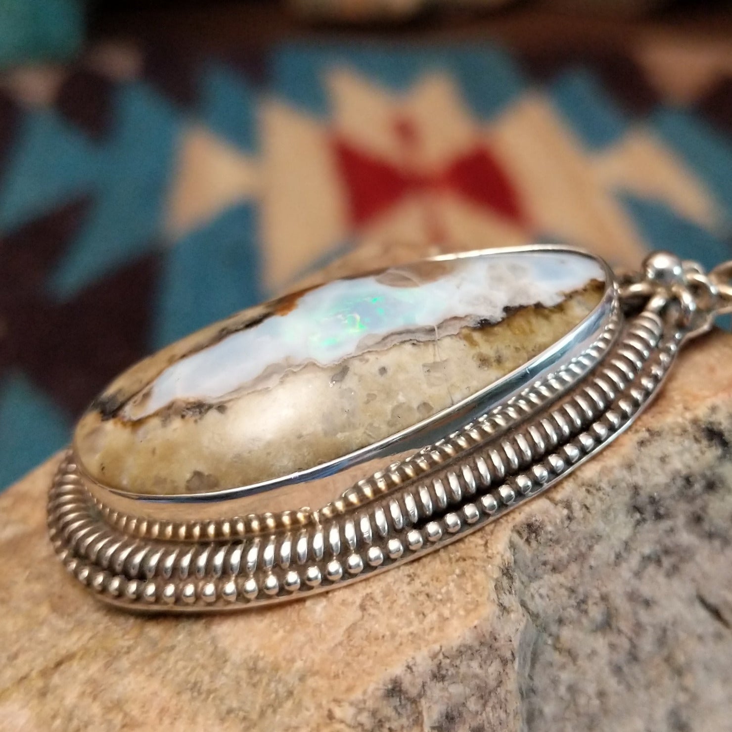 Sterling silver pendant with Arizona blue opal set in the bezel, framed by ornate silverwork accents.