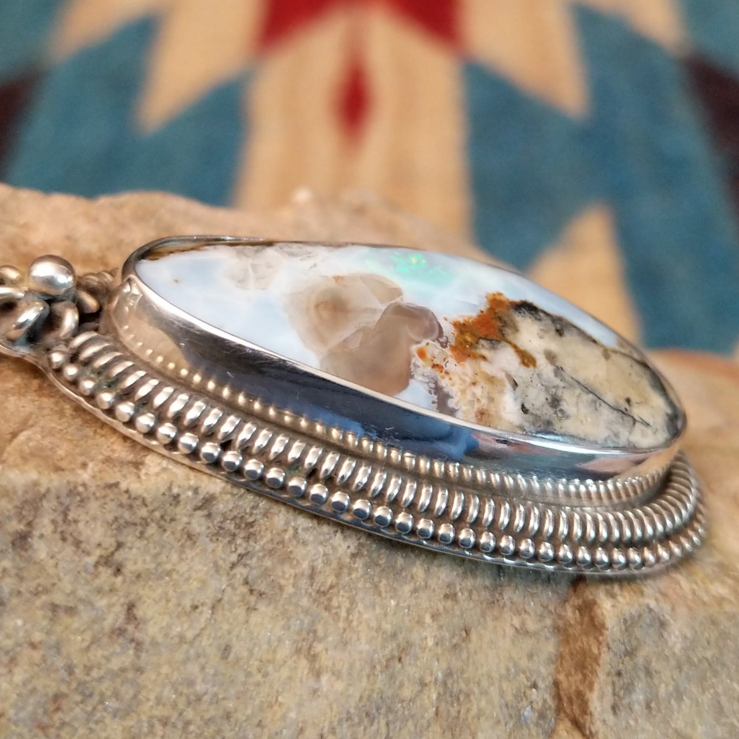 Sterling silver pendant with Arizona blue opal set in the bezel, framed by ornate silverwork accents.
