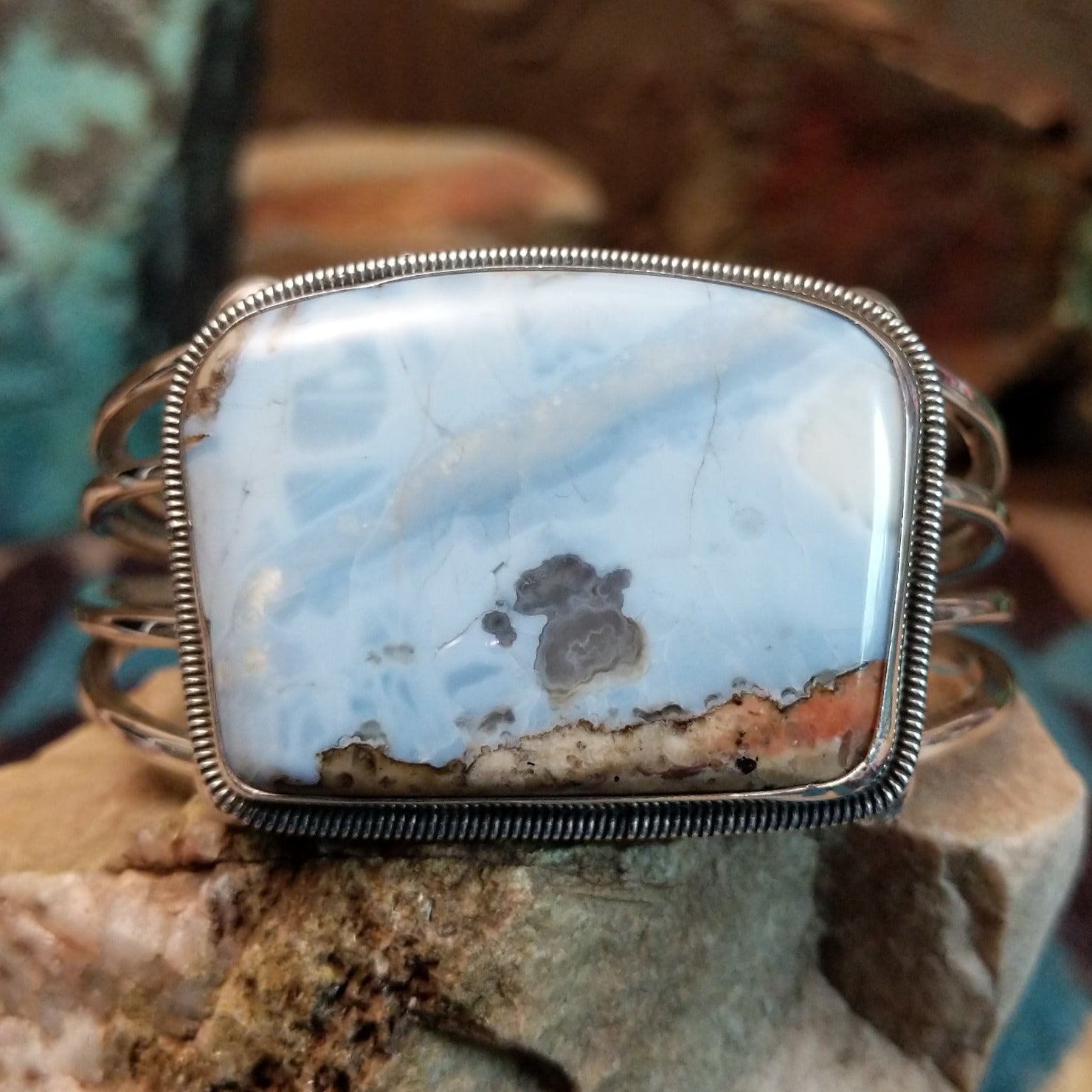 Sterling silver cuff bracelet with Arizona blue opal set in the large bezel, framed by ribbed silverwork.