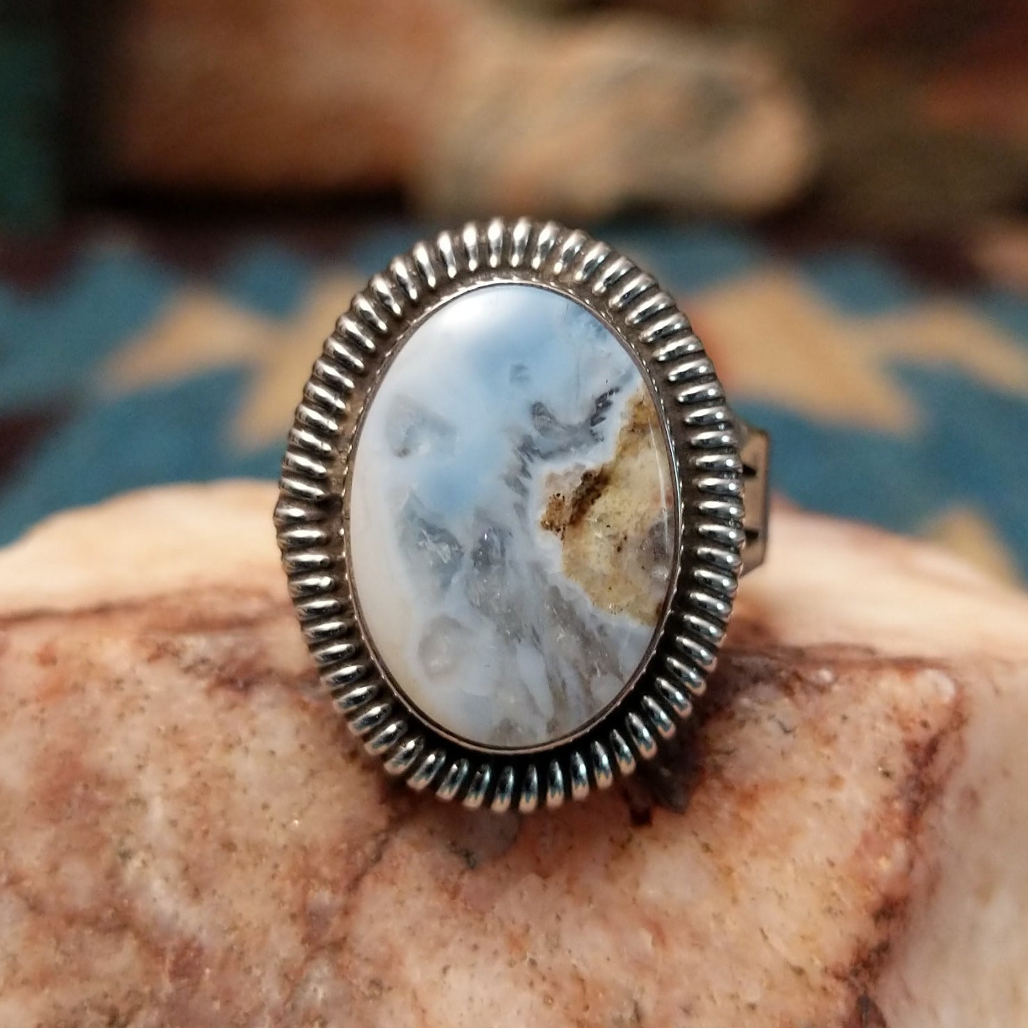 Sterling silver ring with Arizona blue opal set in the oval bezel, framed by ribbed silverwork.