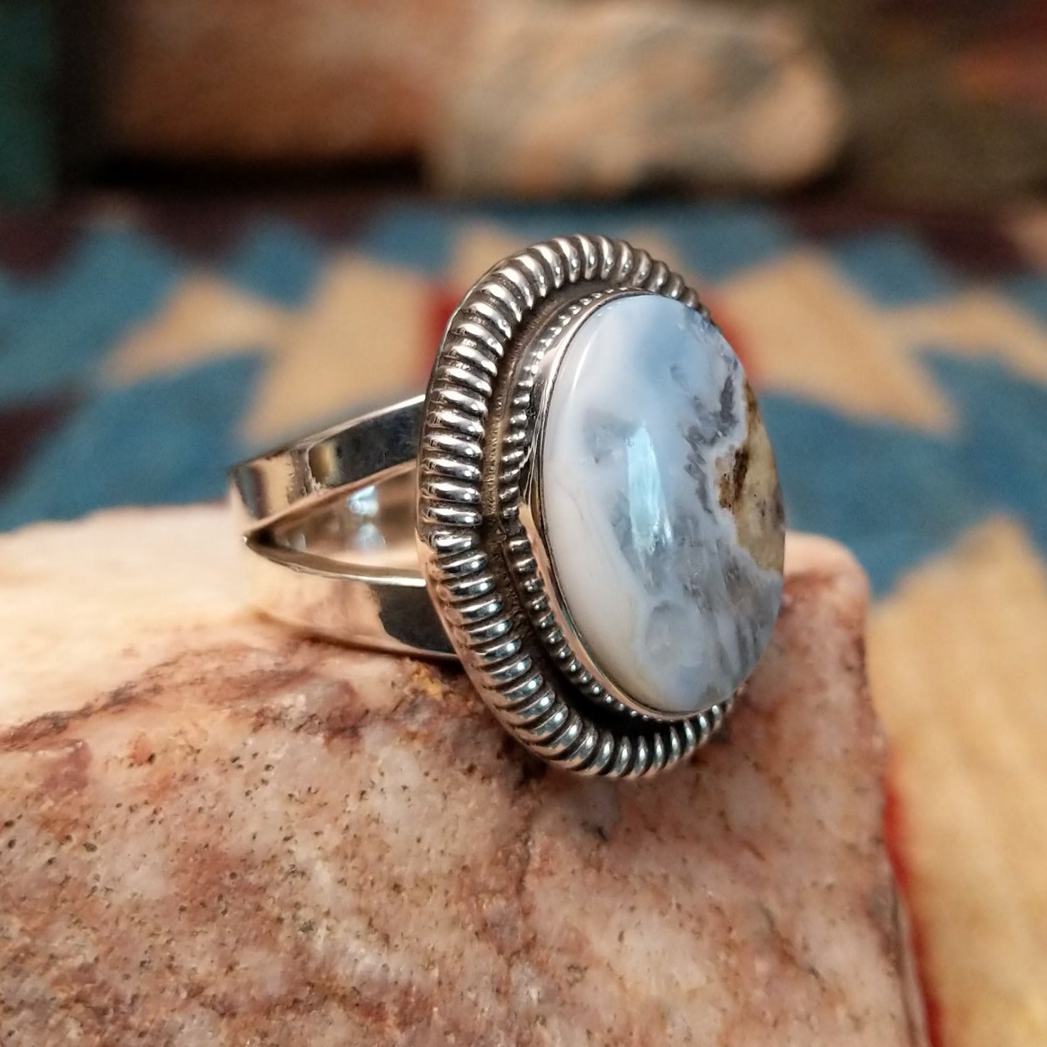 Sterling silver ring with Arizona blue opal set in the oval bezel, framed by ribbed silverwork.