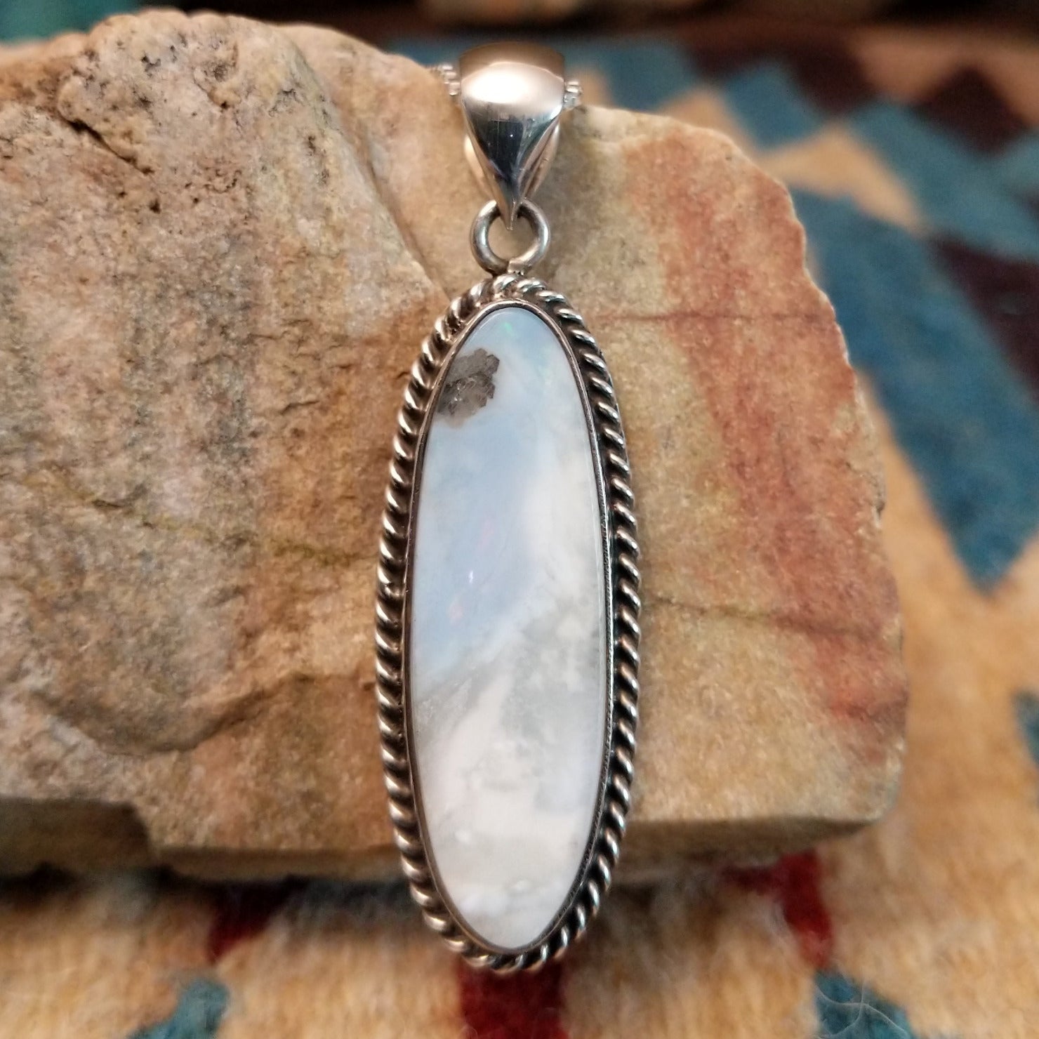 Sterling silver pendant with Arizona blue opal set in the ovoid bezel, framed by twisted rope accents.