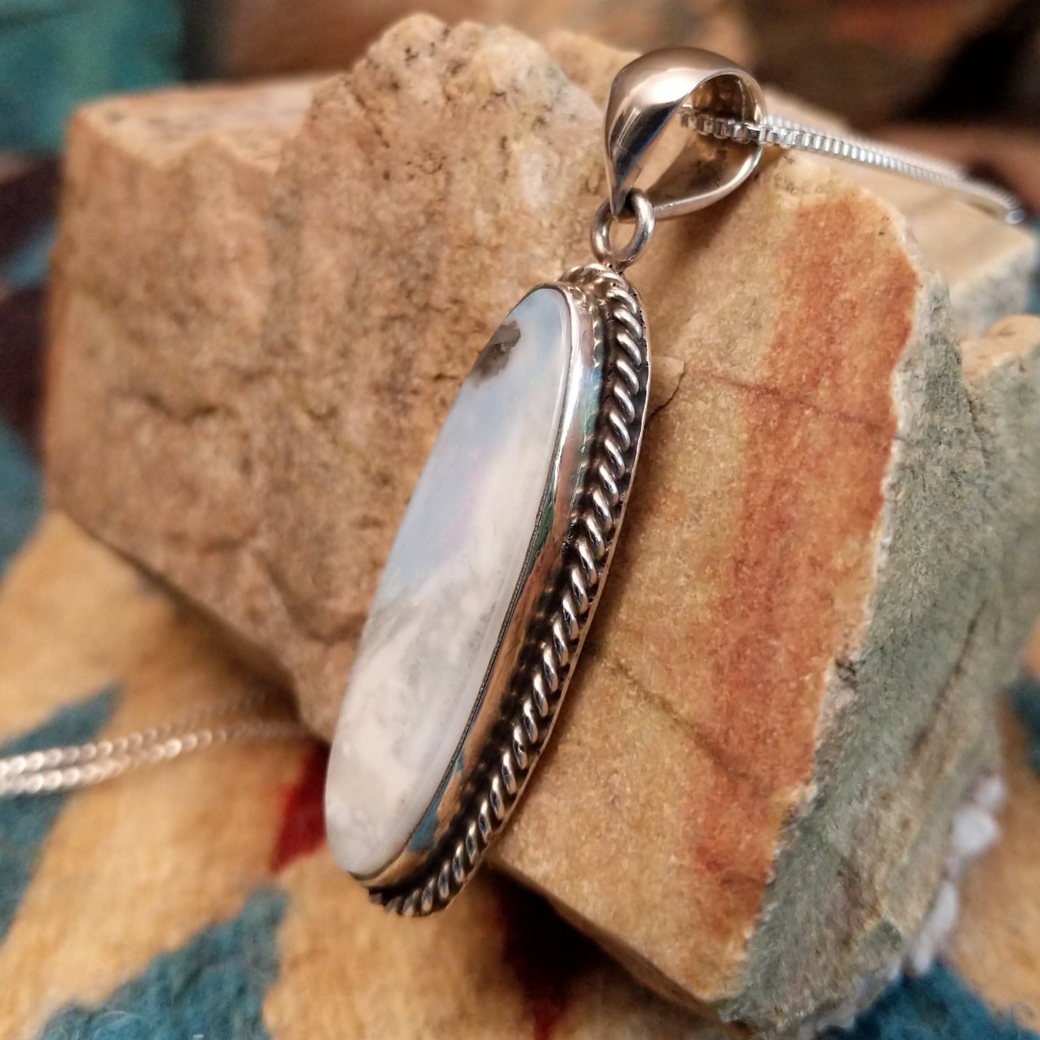 Sterling silver pendant with Arizona blue opal set in the ovoid bezel, framed by twisted rope accents.