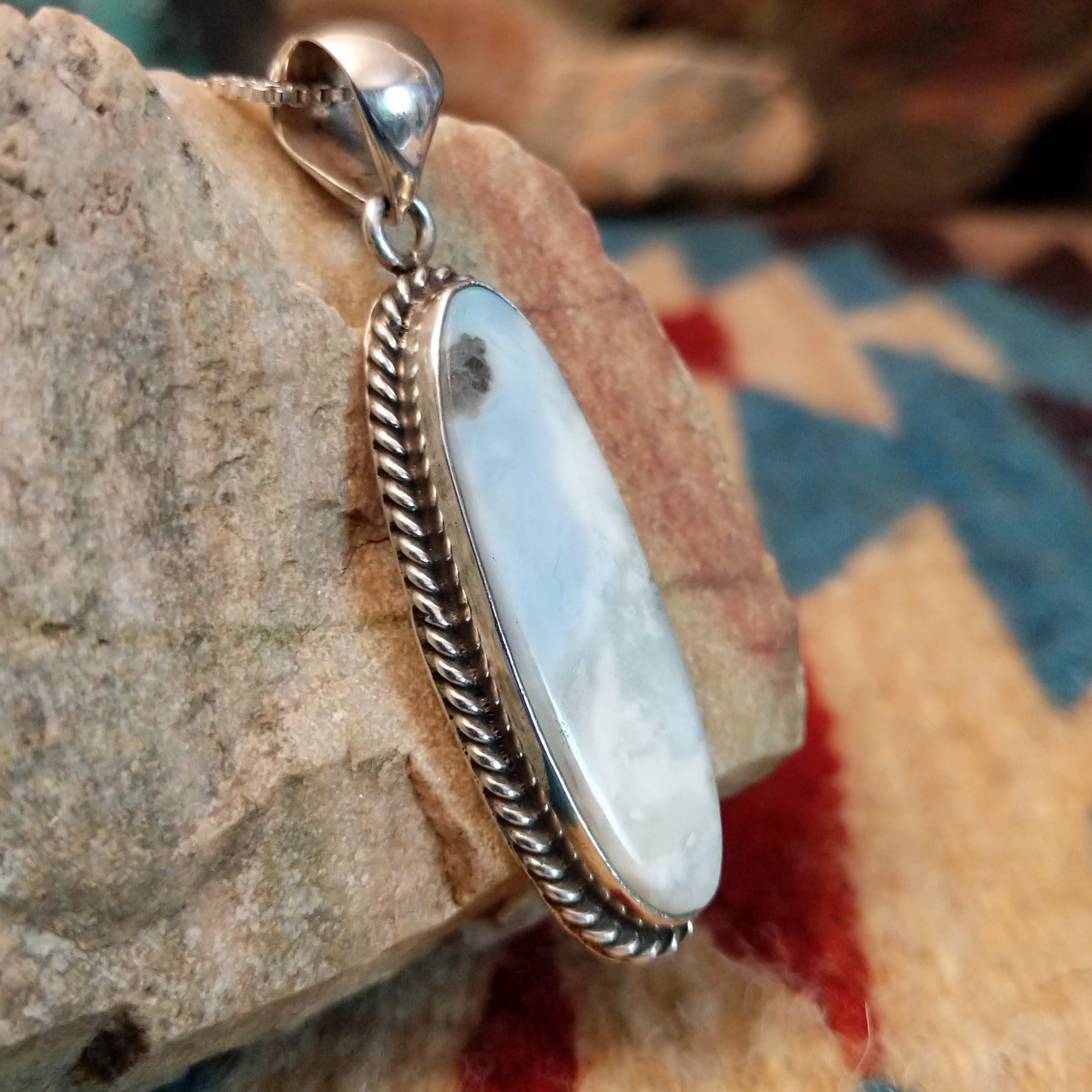 Sterling silver pendant with Arizona blue opal set in the ovoid bezel, framed by twisted rope accents.