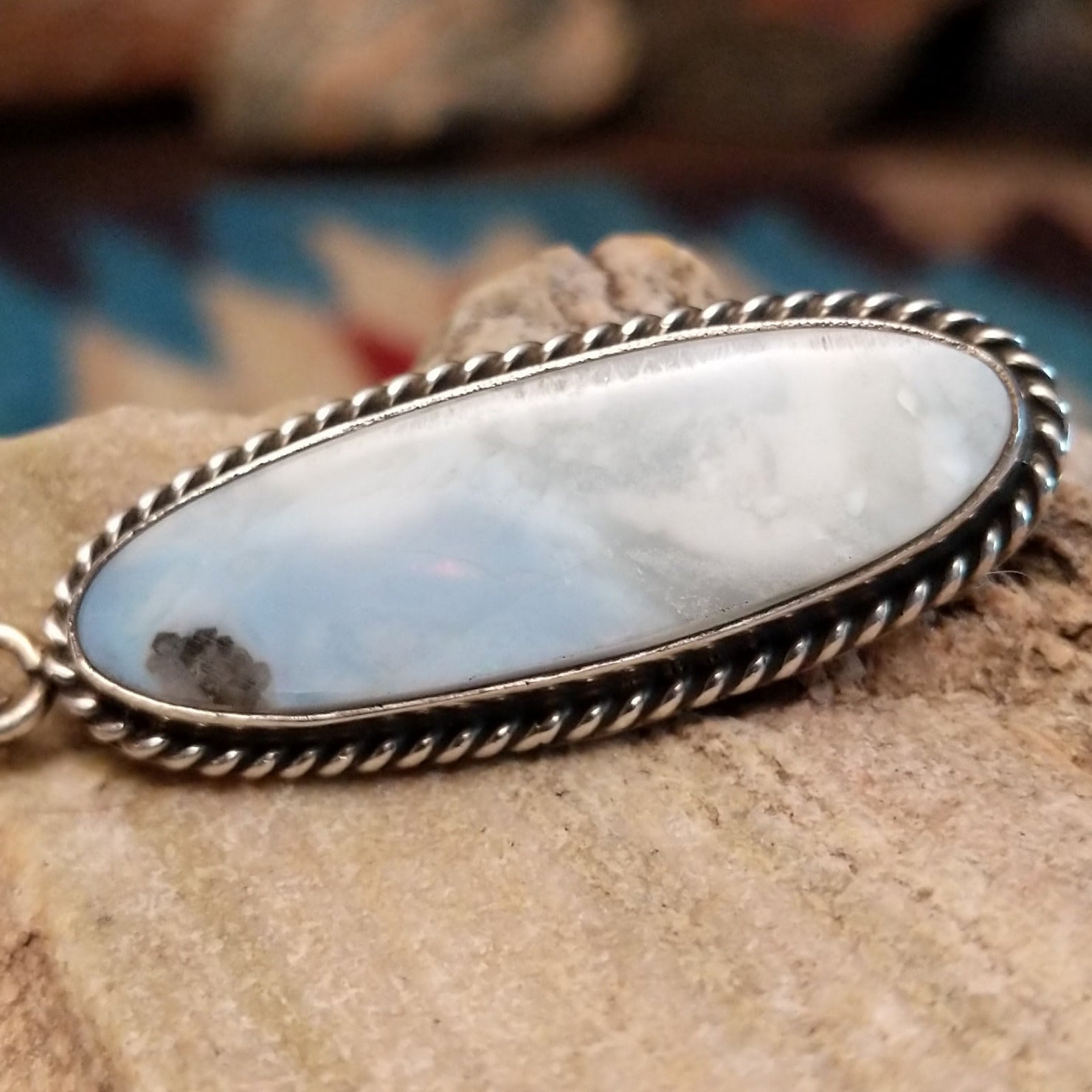 Sterling silver pendant with Arizona blue opal set in the ovoid bezel, framed by twisted rope accents.