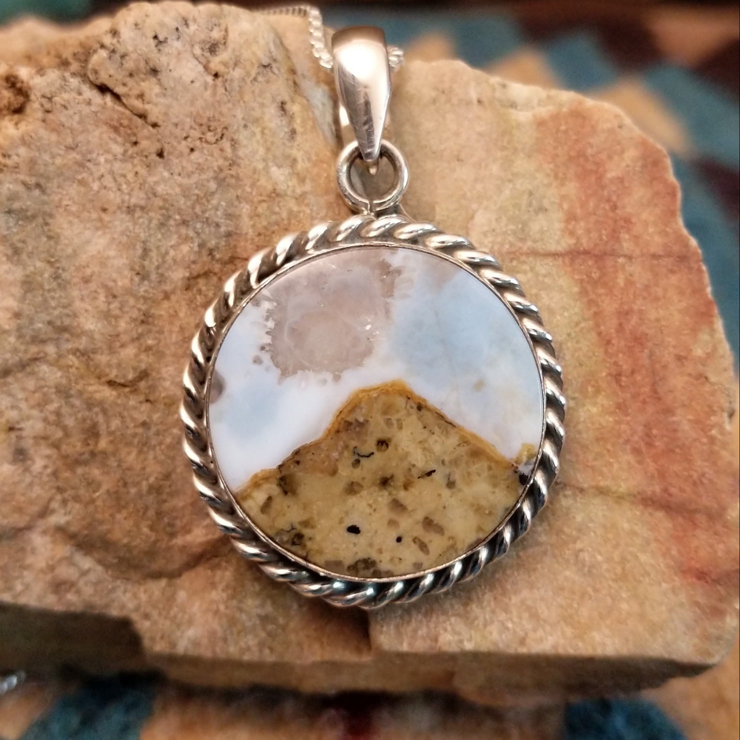 Sterling silver pendant with Arizona blue opal set in the round bezel, framed by twisted rope accents.