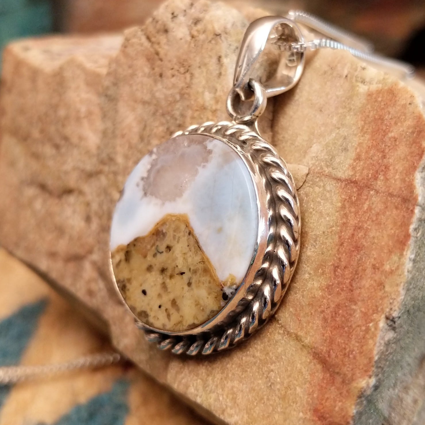 Sterling silver pendant with Arizona blue opal set in the round bezel, framed by twisted rope accents.