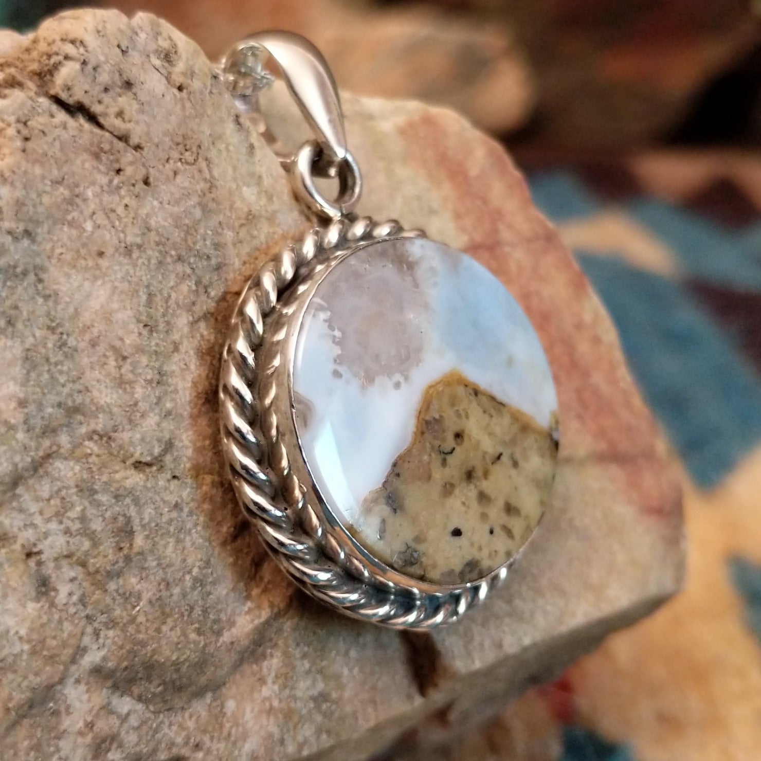 Sterling silver pendant with Arizona blue opal set in the round bezel, framed by twisted rope accents.