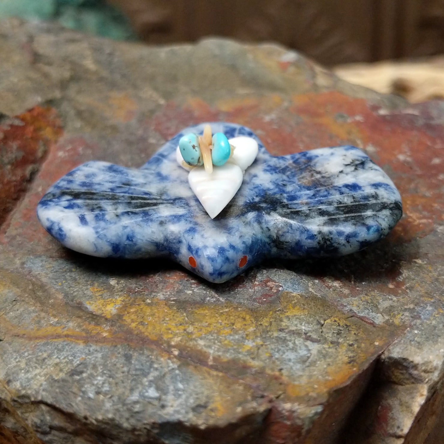 Bat Zuni fetish carving by Leland Boone in blue and white sodalite with a miniature offering bundle featuring turquoise and shell beads.