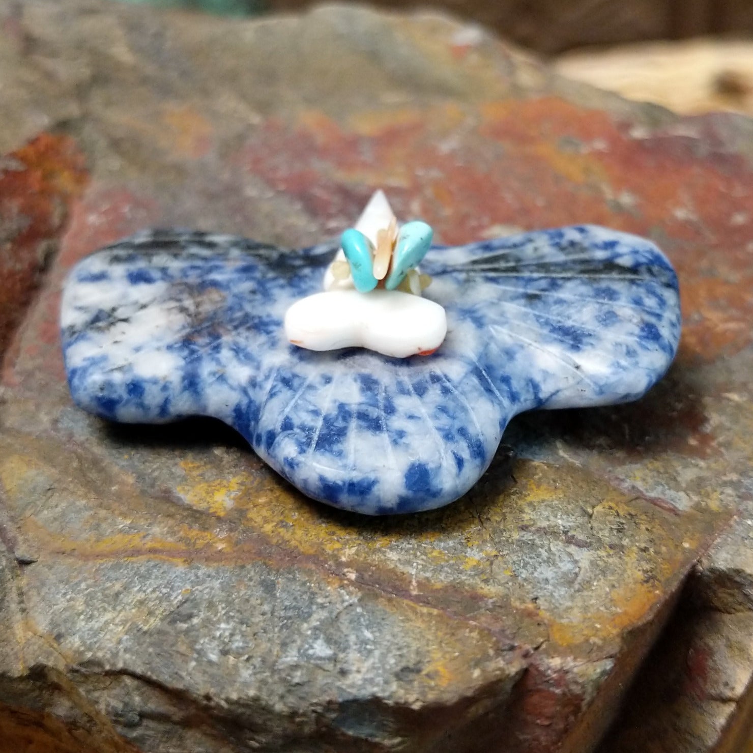 Bat Zuni fetish carving by Leland Boone in blue and white sodalite with a miniature offering bundle featuring turquoise and shell beads.