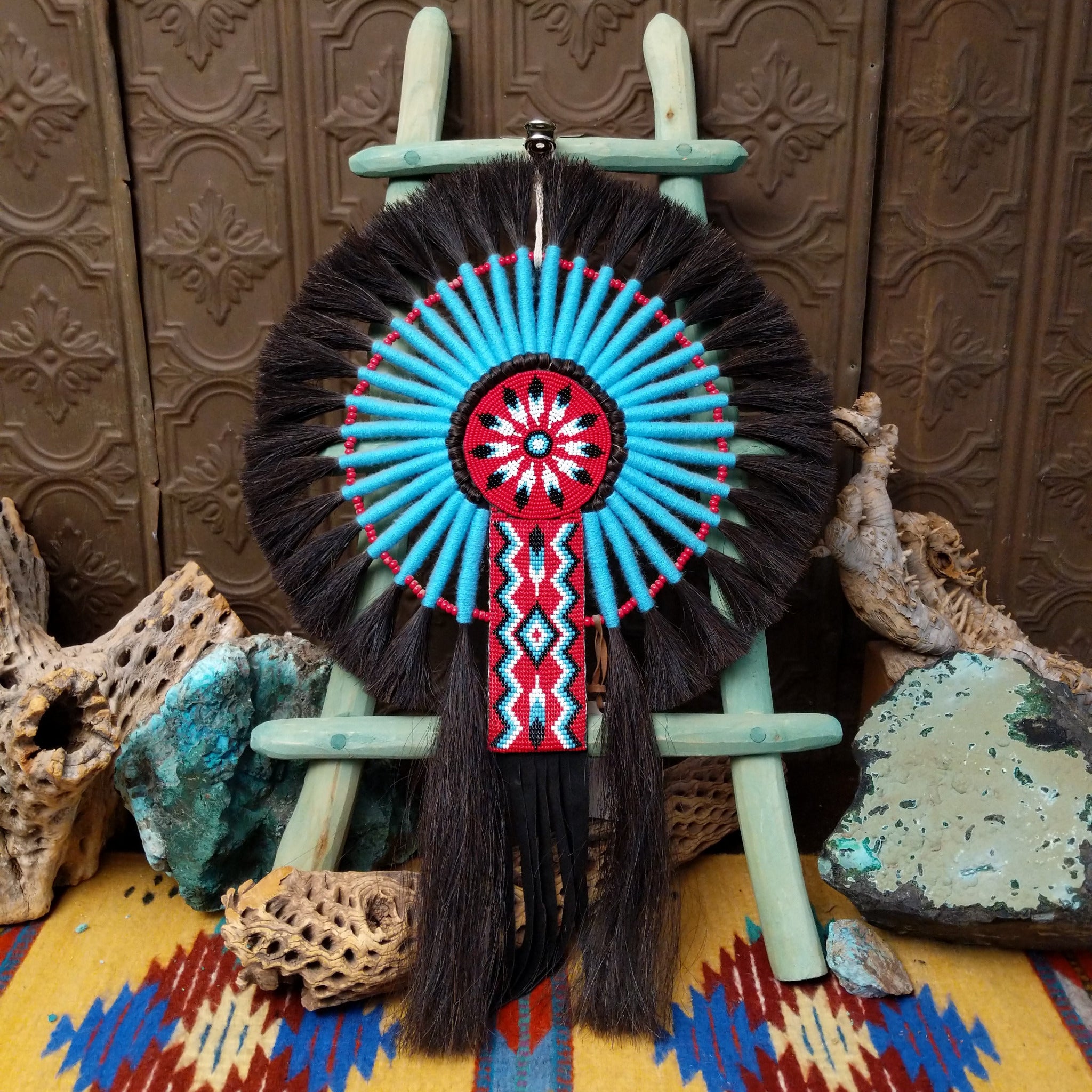Blue Navajo Bustle artifact reproduction by Linda Lee with beadwork by Dorothy Manning, featuring turquoise, red, black, and white beadwork with dark horsehair accents.