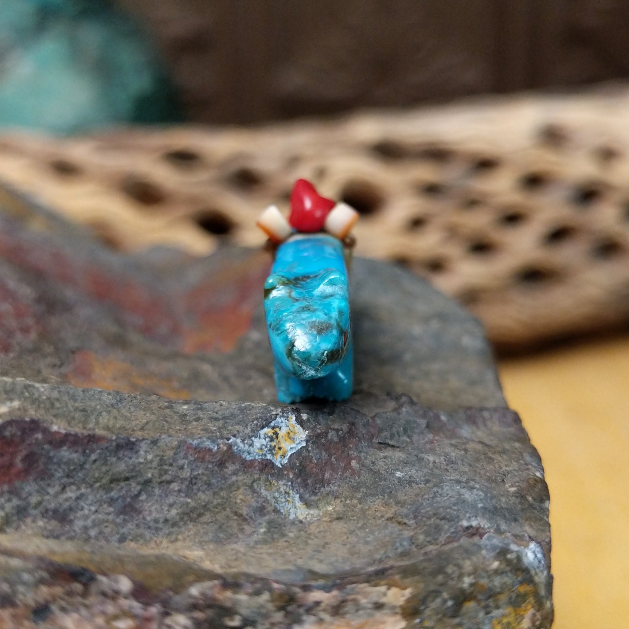 Cougar Zuni fetish by LaVies Natewa carved from turquoise with a medicine bundle on its back.