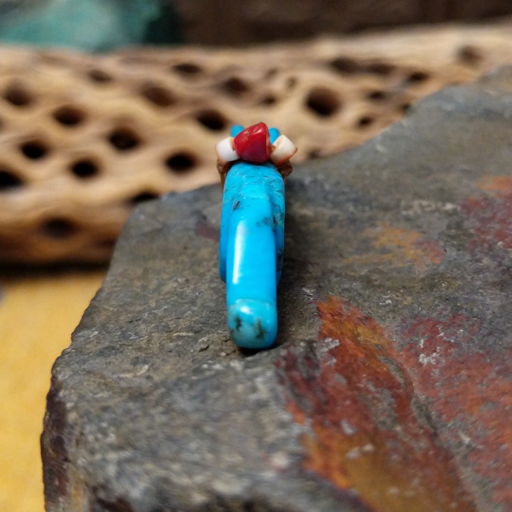Cougar Zuni fetish by LaVies Natewa carved from turquoise with a medicine bundle on its back.