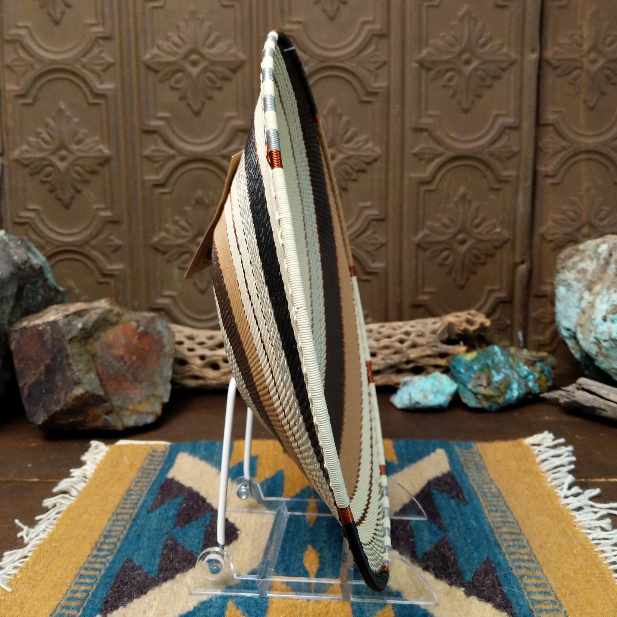 Handwoven large earth tone wire art bowl by Bridge for Africa featuring a spiral pattern in recycled wire with ivory, beige, taupe, gray, brown, and black tones, perfect for home décor or wall display; side view.