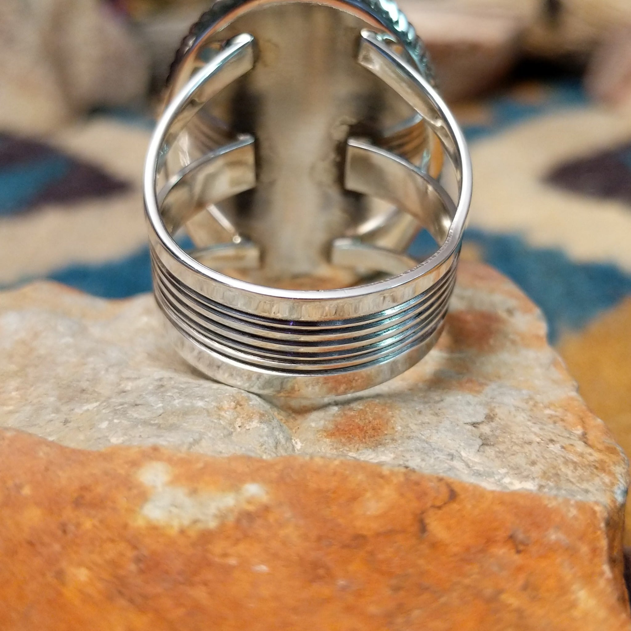 Handcrafted sterling silver Navajo ring by Alvin Joe featuring a large oval natural turquoise cabochon with subtle matrix, set in a classic twisted rope bezel; underside view.