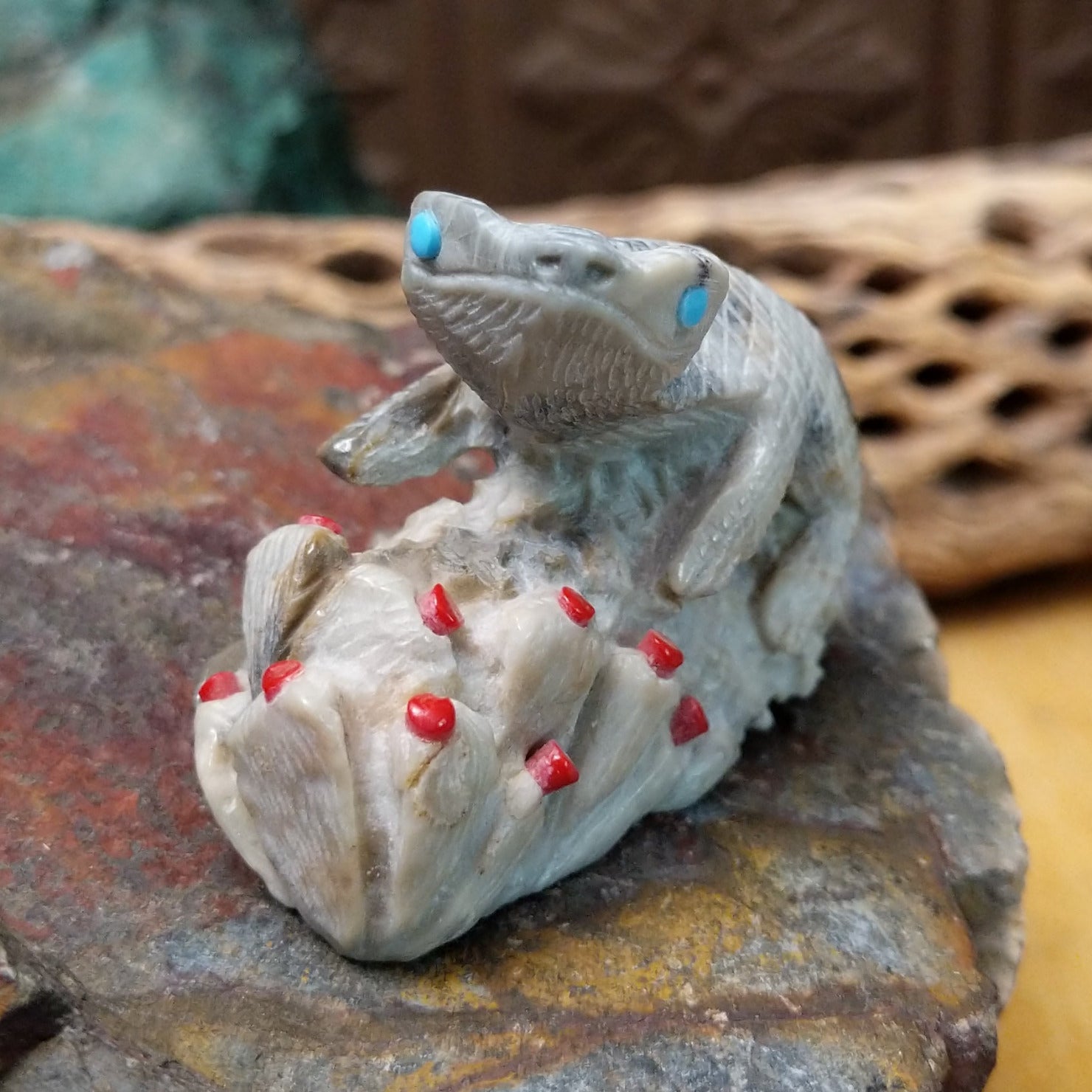 Lizard and prickly pear Zuni fetish carving by Alvin Haloo with turquoise inlaid eyes and red prickly pear fruit accents.