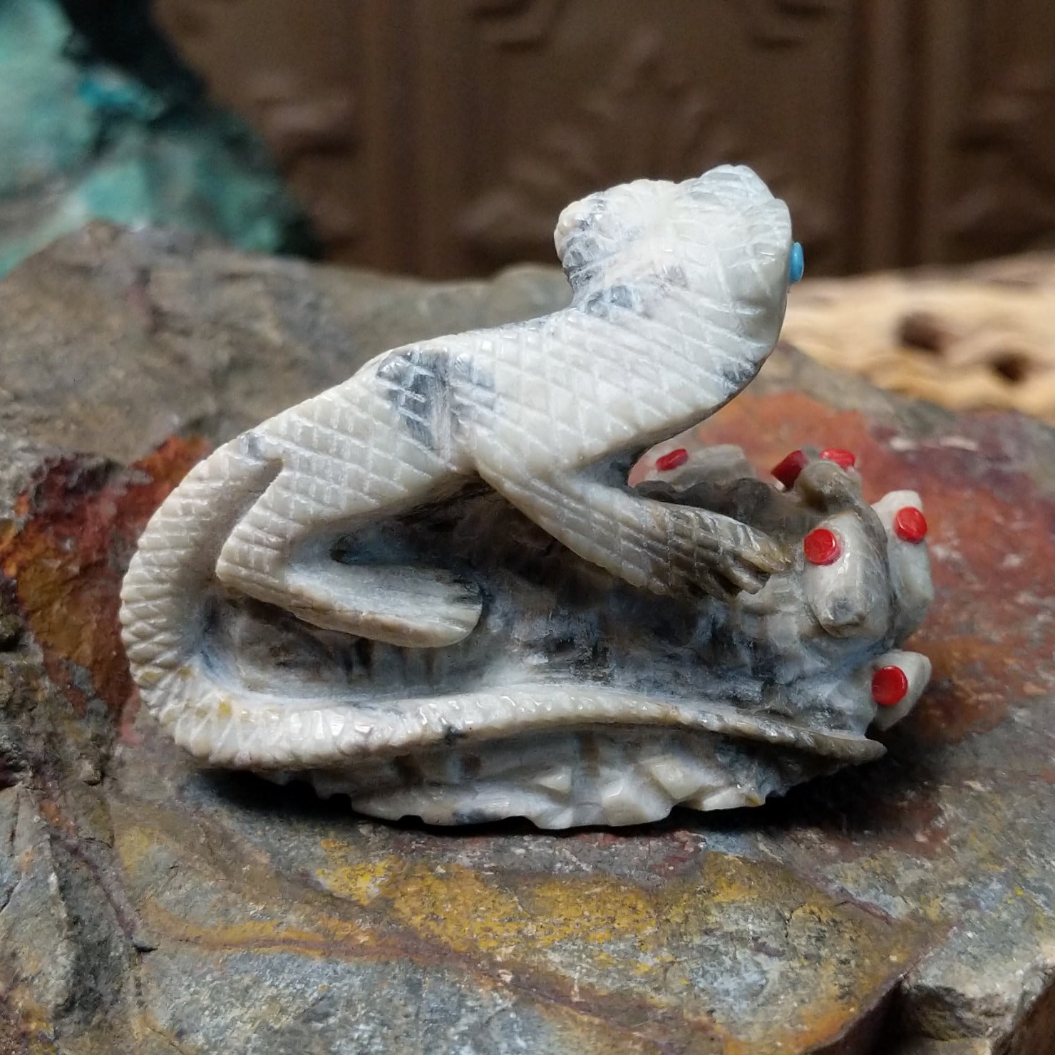 Lizard and prickly pear Zuni fetish carving by Alvin Haloo with turquoise inlaid eyes and red prickly pear fruit accents.