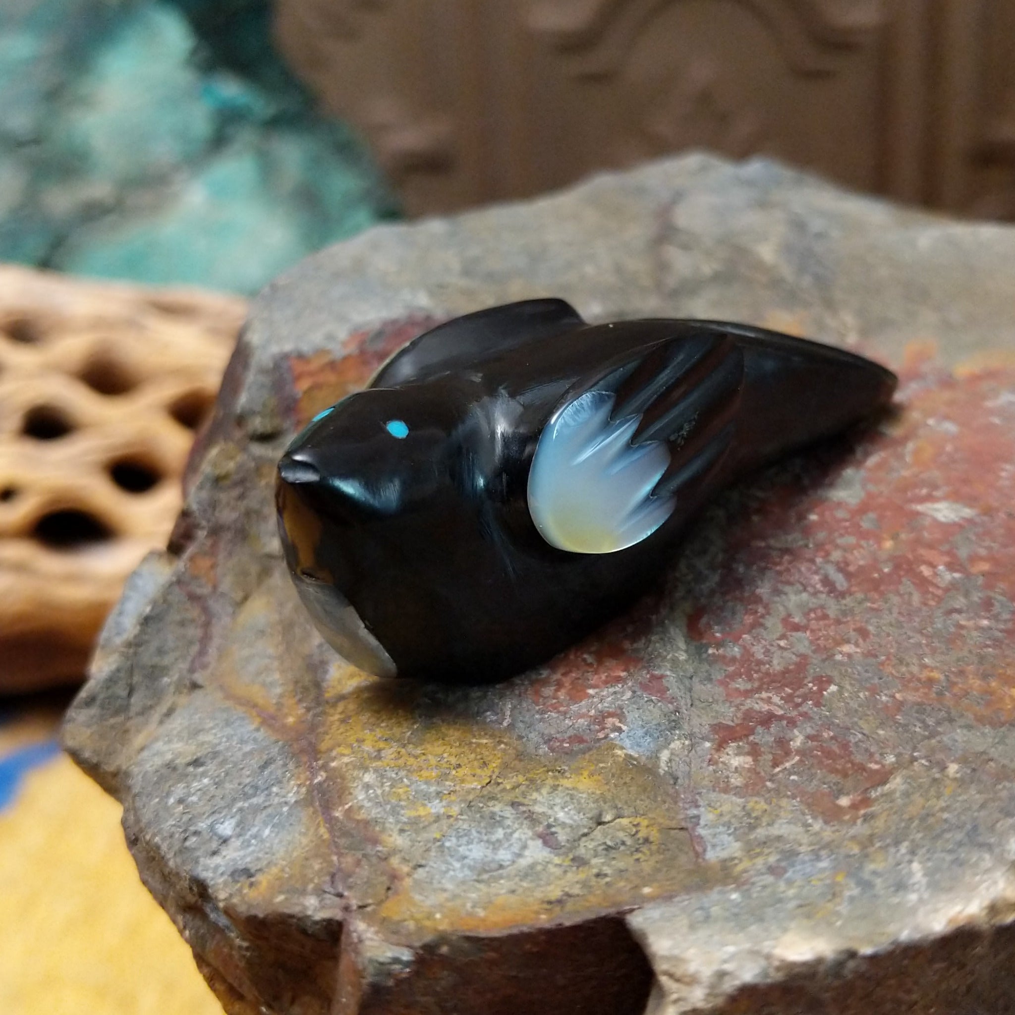 Magpie Zuni fetish carving by Delvin Leekya in black stone with shell wing inlay and turquoise eye.