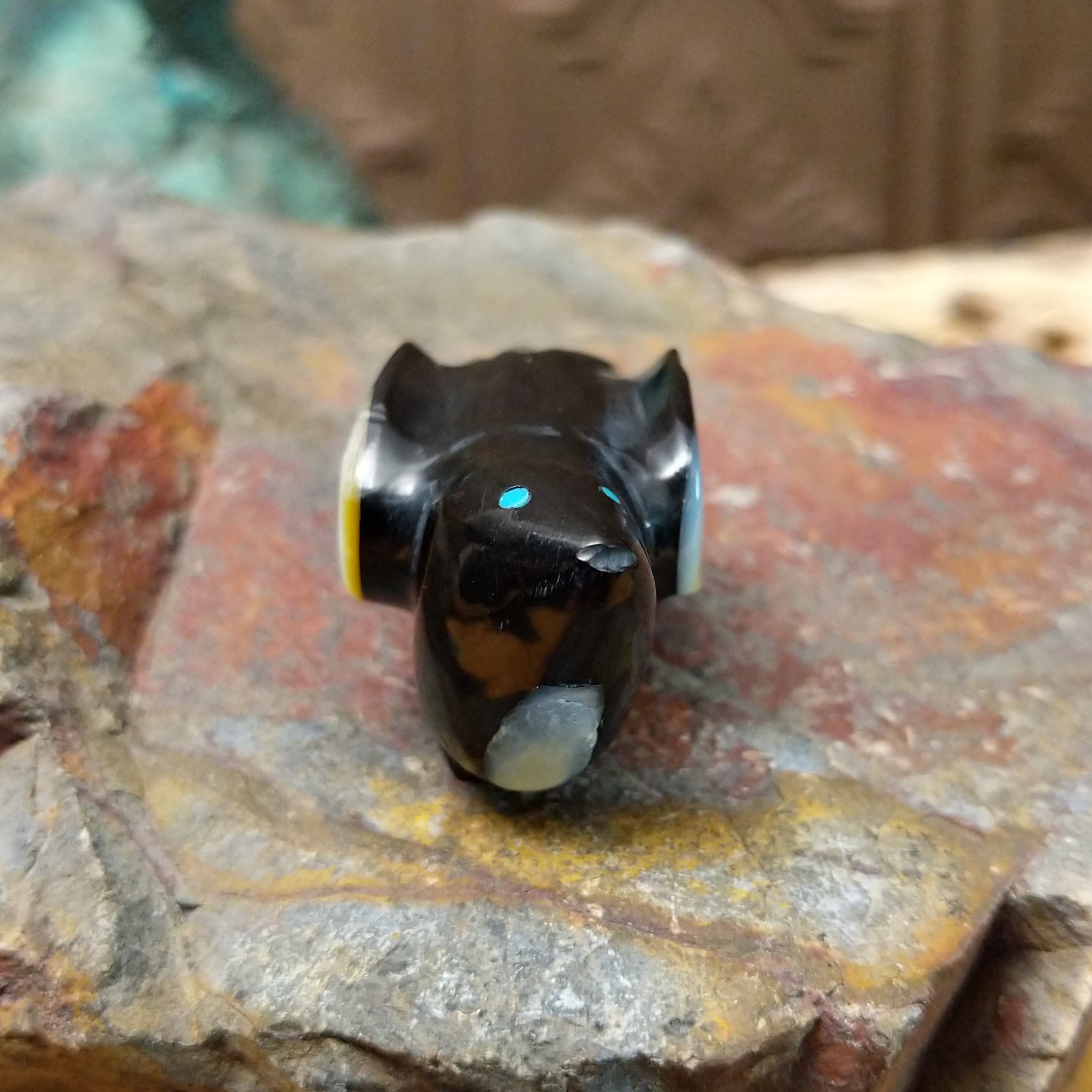 Magpie Zuni fetish carving by Delvin Leekya in black stone with shell wing inlay and turquoise eye.