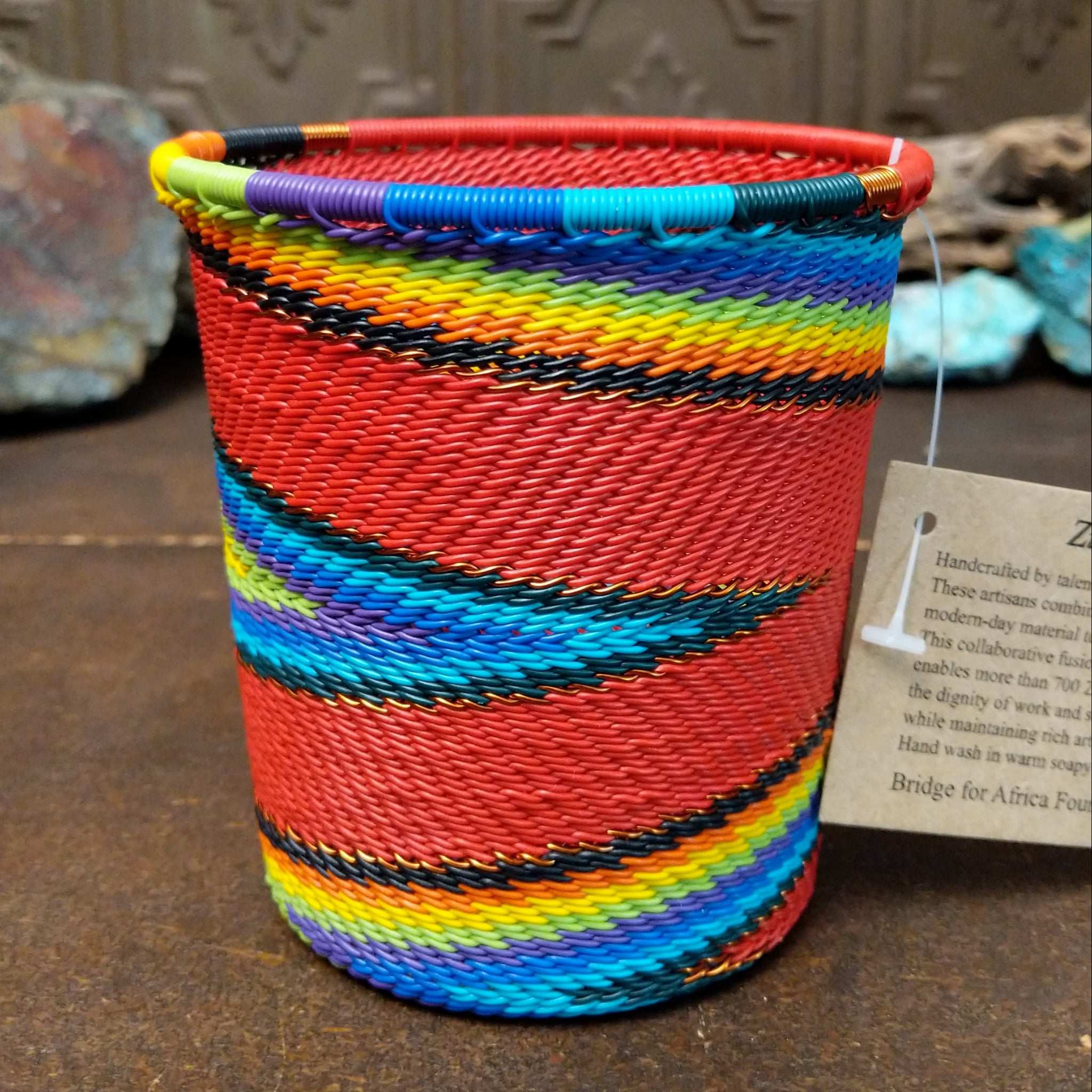 Handwoven multicolor wire art cup by Bridge for Africa featuring vibrant recycled wire in a colorful diagonal pattern, ideal as a decorative container, utensil holder, or pencil cup.