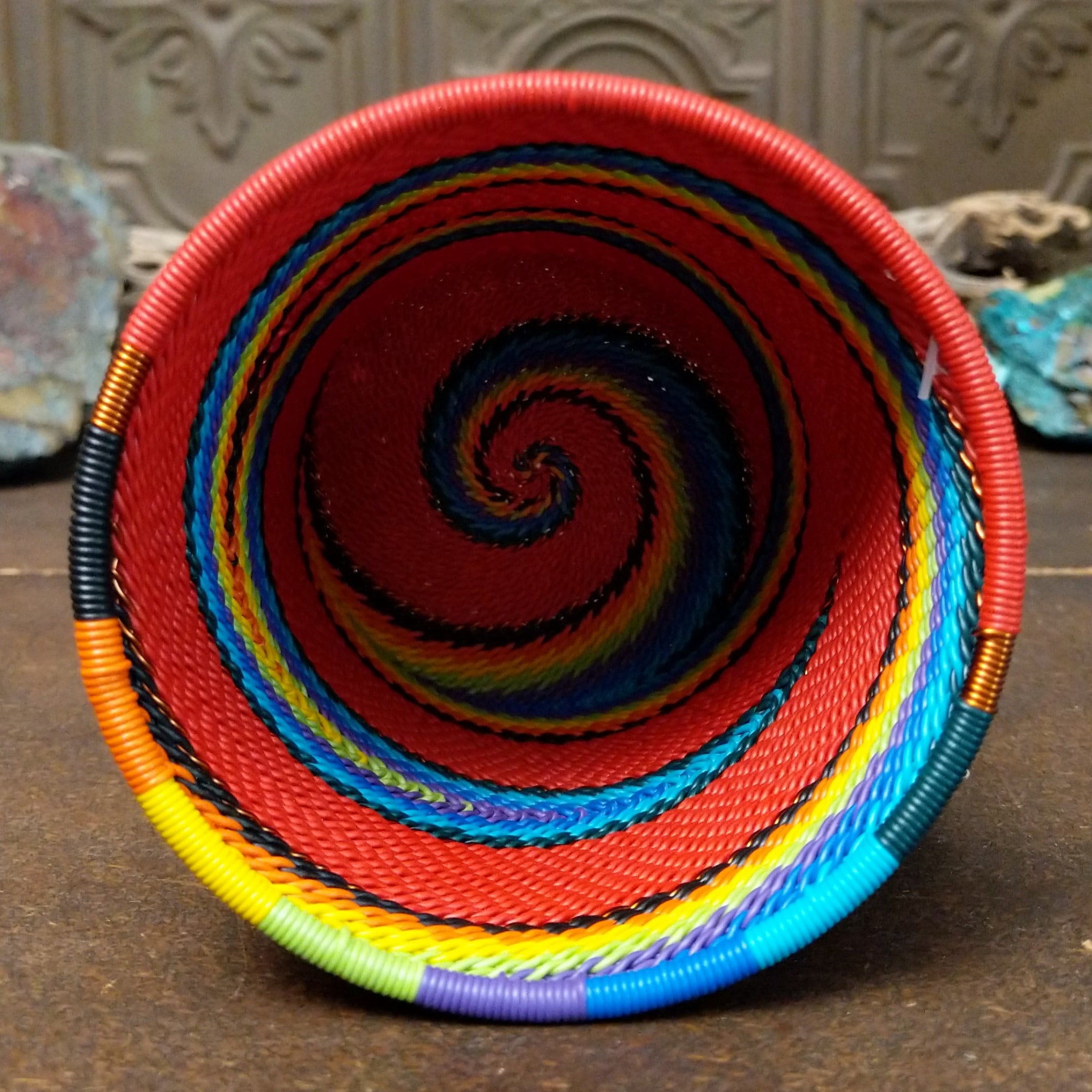 Handwoven multicolor wire art cup by Bridge for Africa featuring vibrant recycled wire in a colorful diagonal pattern, ideal as a decorative container, utensil holder, or pencil cup; interior view.