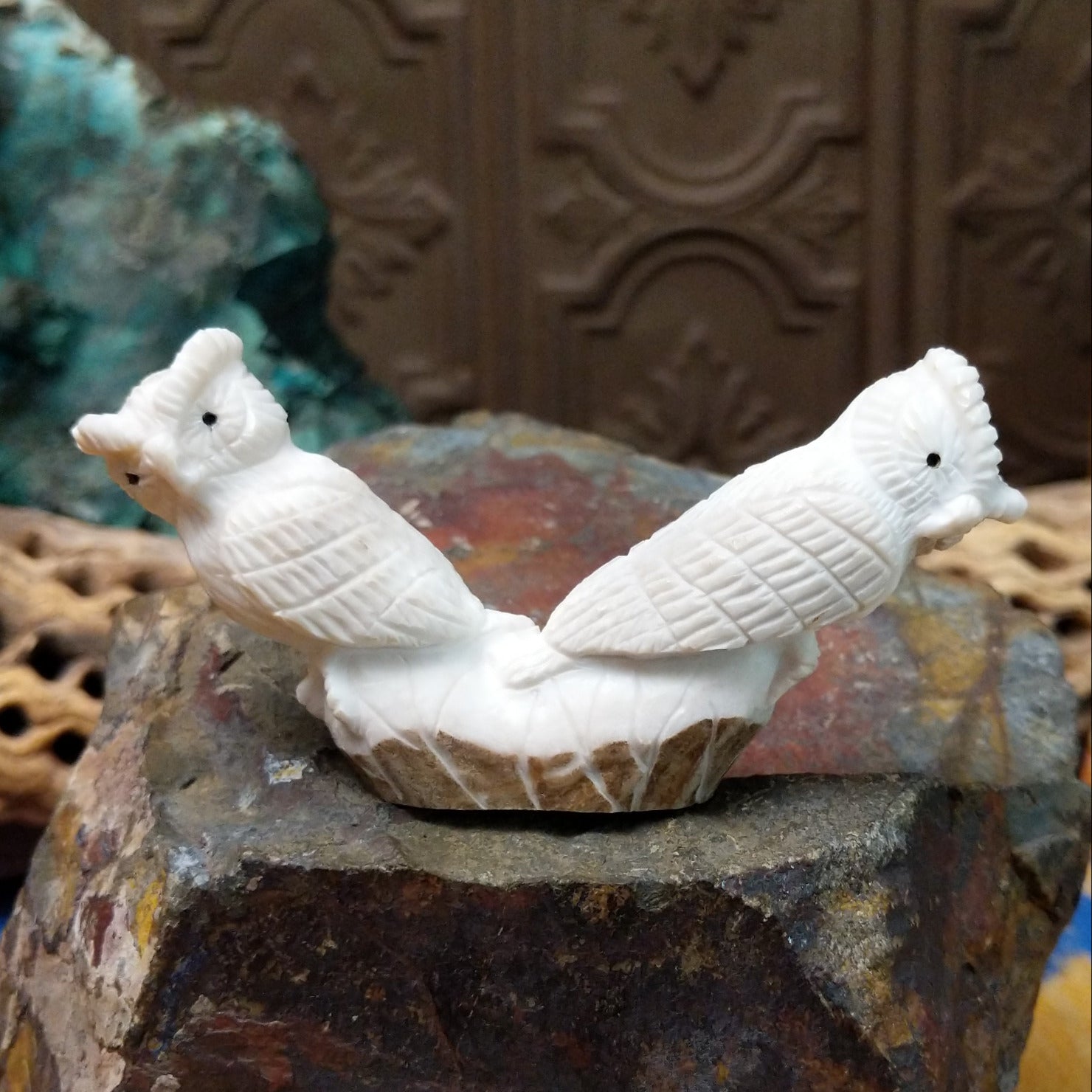 Zuni owl fetish carving by Chris Peina featuring two white stone owls with black inlaid eyes perched back to back on a shared base.
