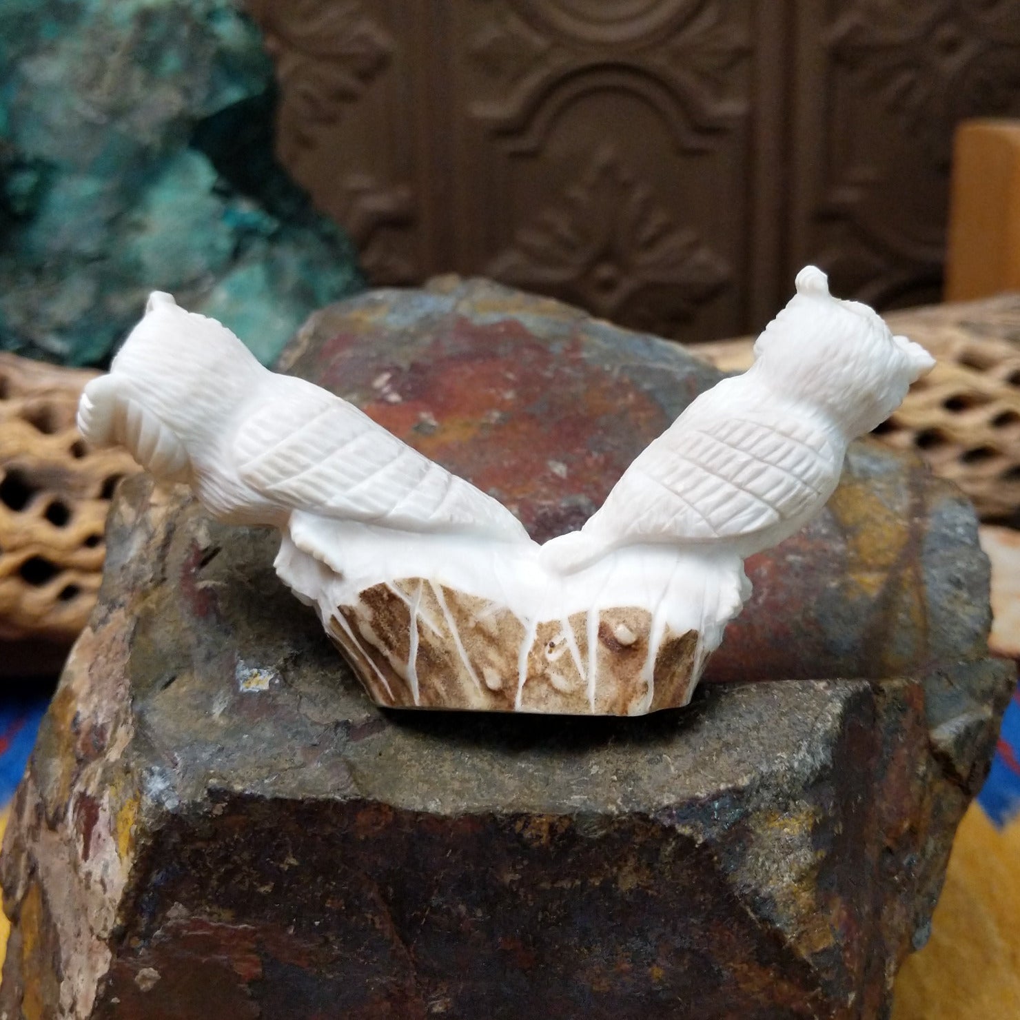 Zuni owl fetish carving by Chris Peina featuring two white stone owls with black inlaid eyes perched back to back on a shared base.