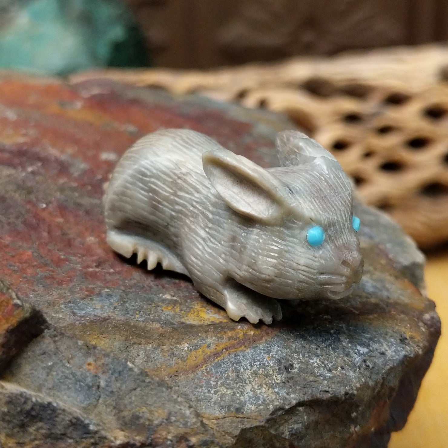 Zuni rabbit fetish carving by Bernie Laselute with carved fur texture and turquoise inlaid eyes.