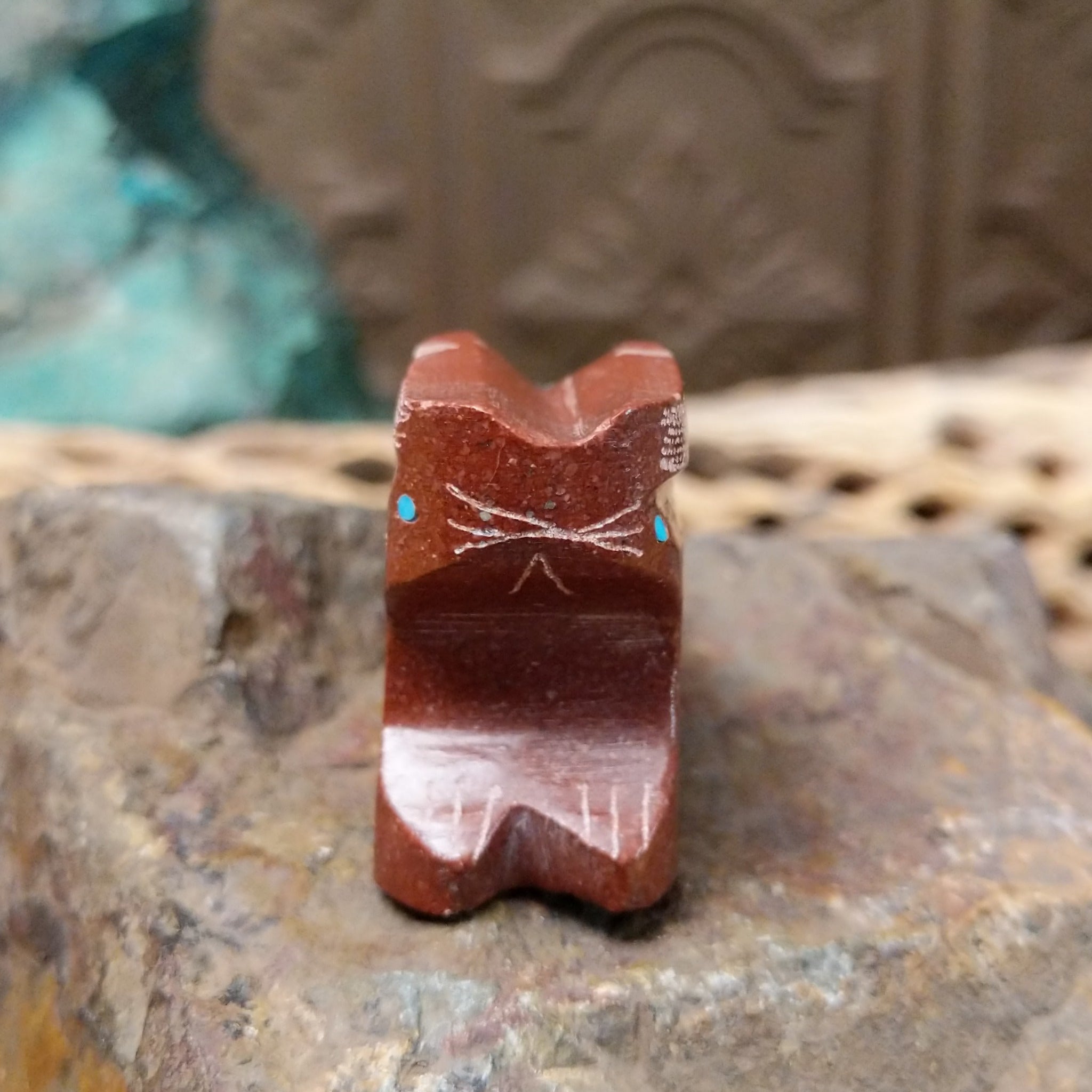 Rabbit Zuni fetish carving by Patrick Wallace in red stone with an engraved arrow motif and turquoise inlaid eye.