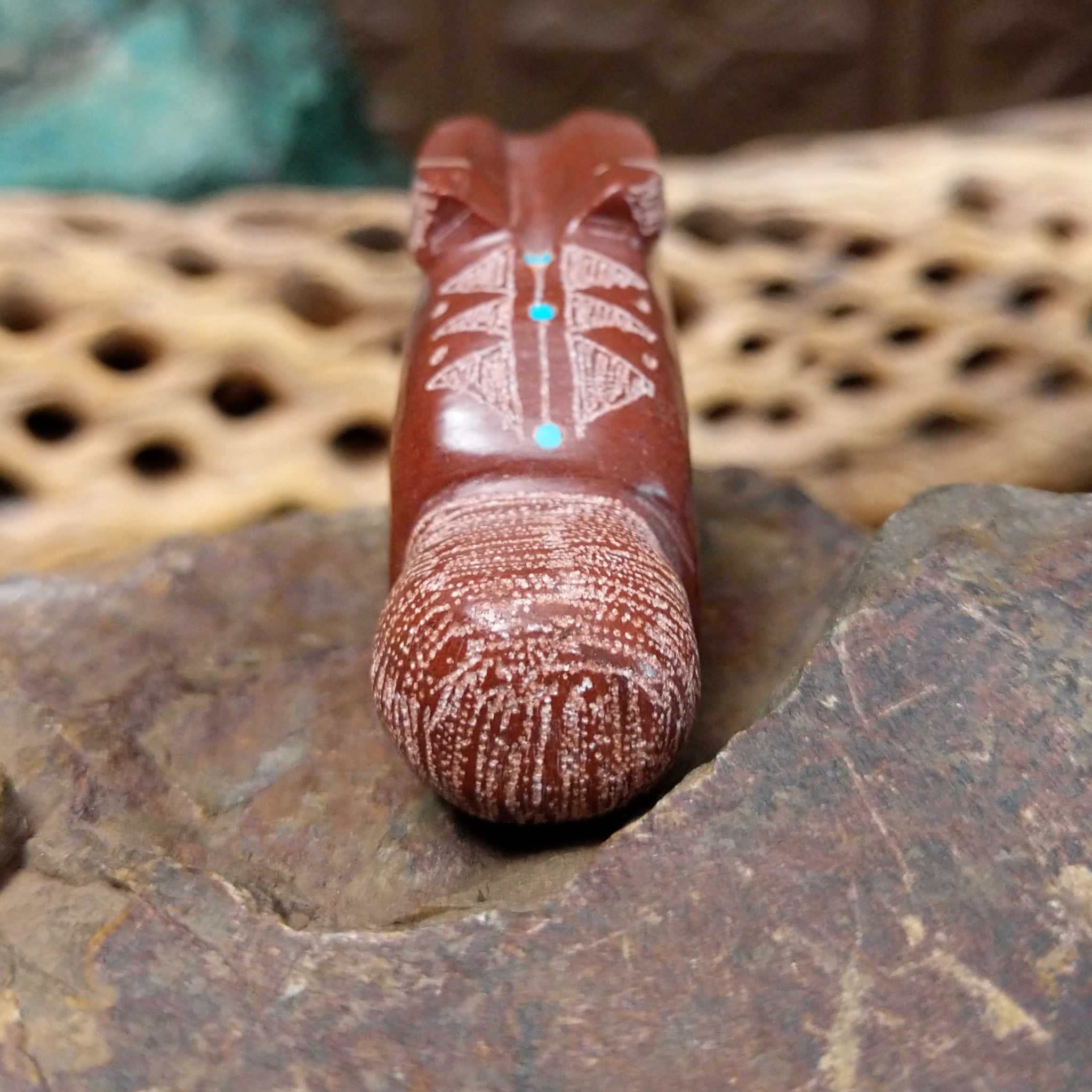 Rabbit Zuni fetish carving by Patrick Wallace in red stone with an engraved arrow motif and turquoise inlaid eye.