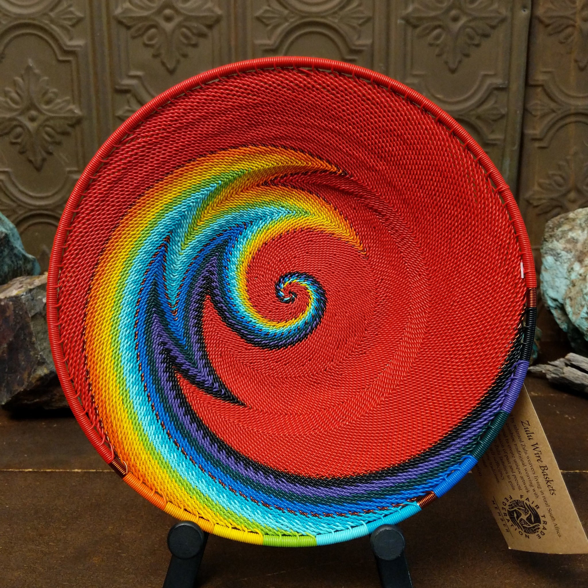 Handwoven rainbow wire art basket by Bridge for Africa featuring colorful recycled wire in a vibrant geometric pattern, ideal as a decorative bowl or wall display.