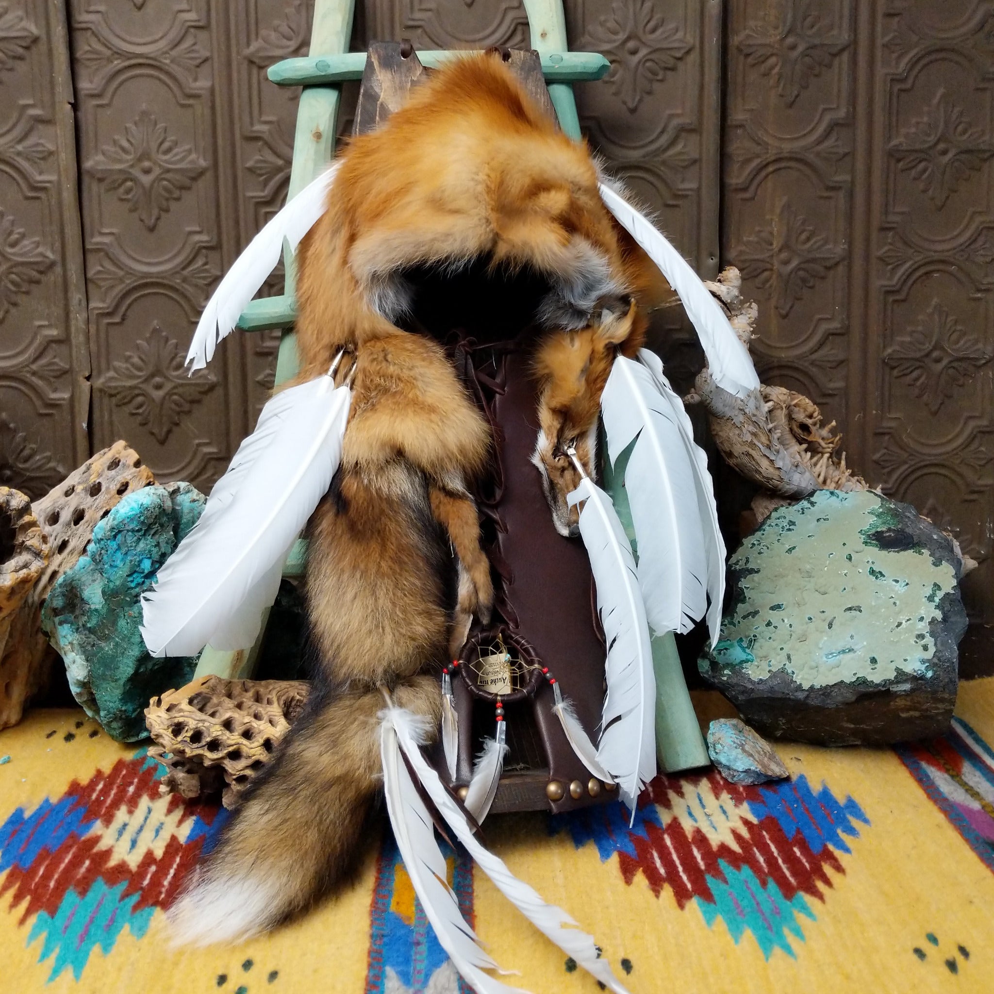 Red Fox Cradleboard artifact reproduction by Lyrissa Lee Chavez-Nelson featuring a red fox pelt, leather backing, and white feather accents.
