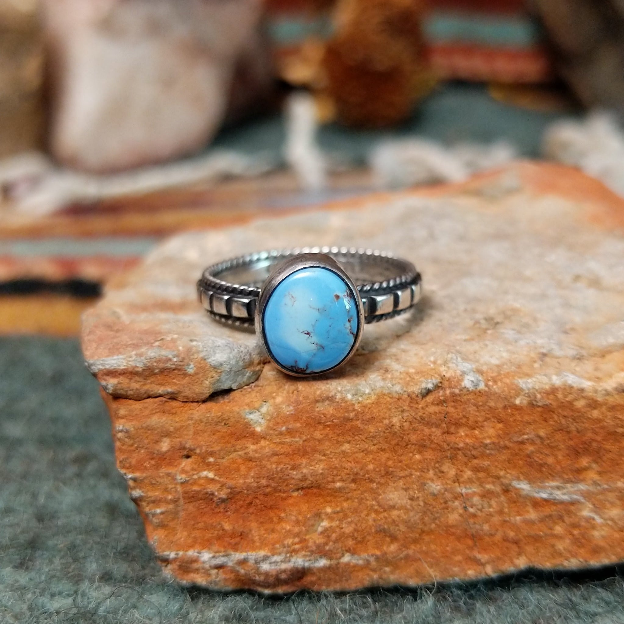 Sterling silver ring by Elgin Tom featuring an oval Golden Hills turquoise stone with natural matrix and a detailed silver band.