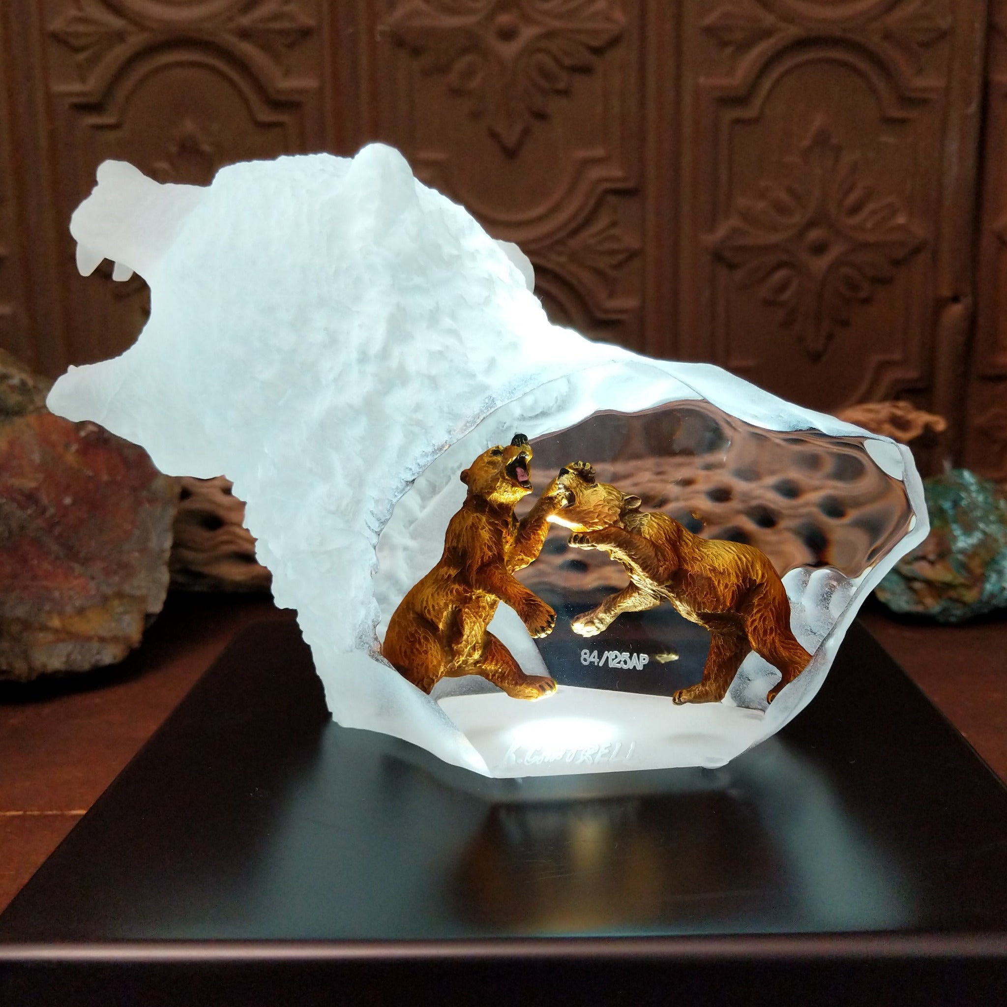 A frosted Lucite sculpture of a roaring grizzly bear with two hand-painted grizzly bears facing off inside the clear crystal interior; low light display.
