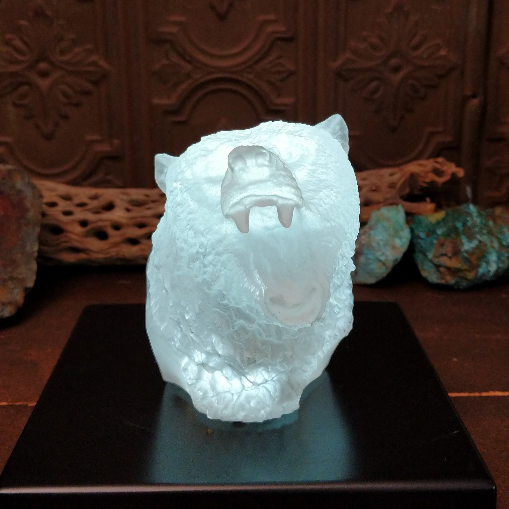 A frosted Lucite sculpture of a roaring grizzly bear with two hand-painted grizzly bears facing off inside the clear crystal interior; low light display.