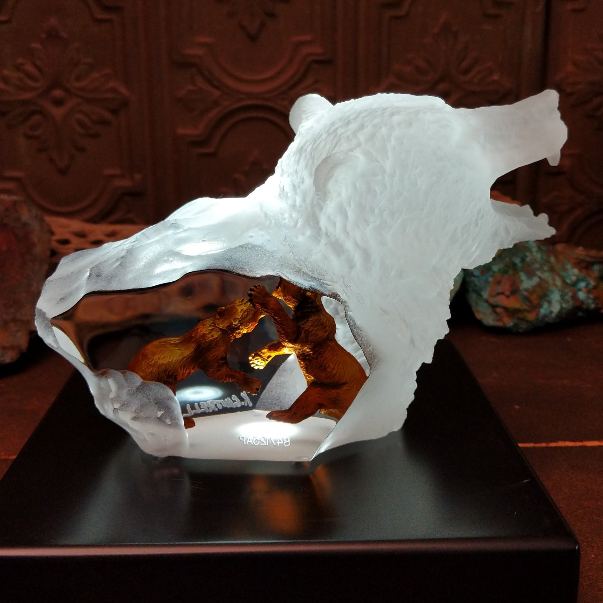 A frosted Lucite sculpture of a roaring grizzly bear with two hand-painted grizzly bears facing off inside the clear crystal interior; low light display.