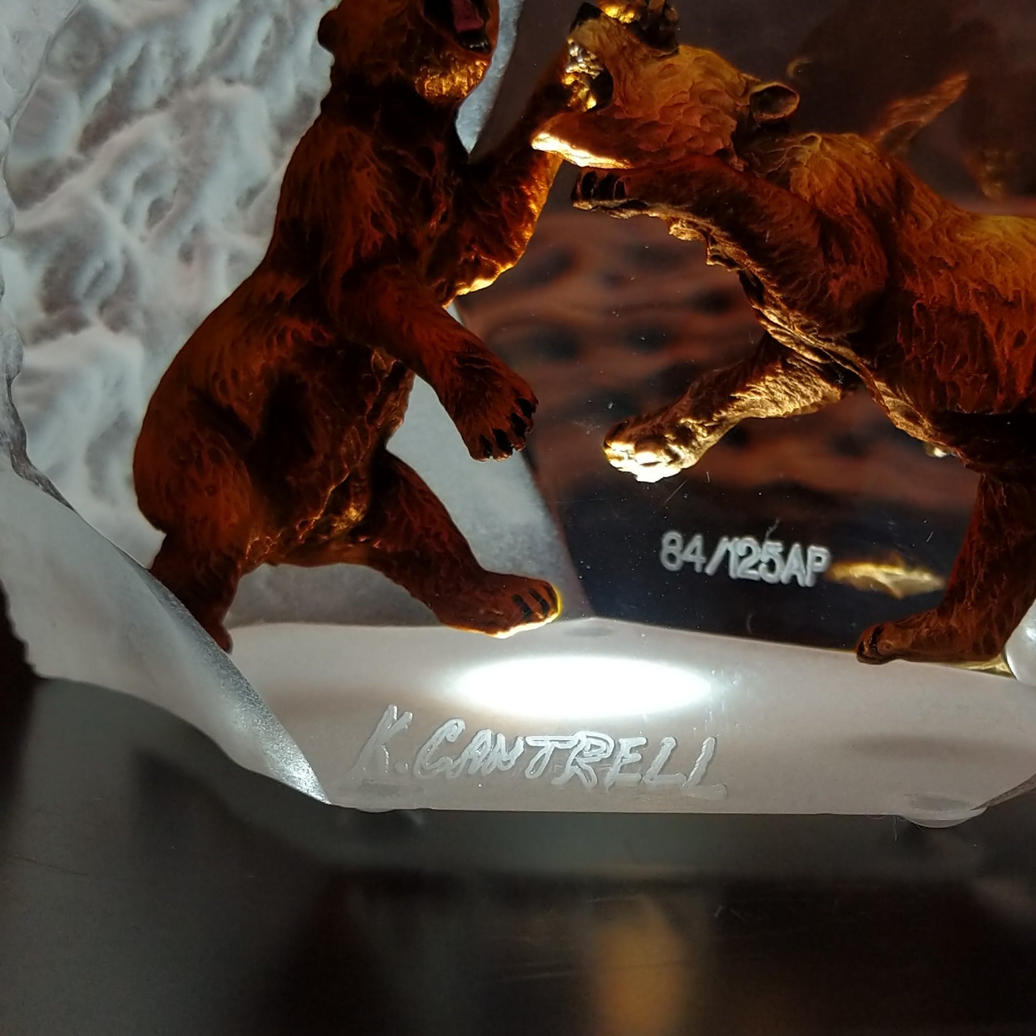 A frosted Lucite sculpture of a roaring grizzly bear with two hand-painted grizzly bears facing off inside the clear crystal interior; artisan signature and production number.