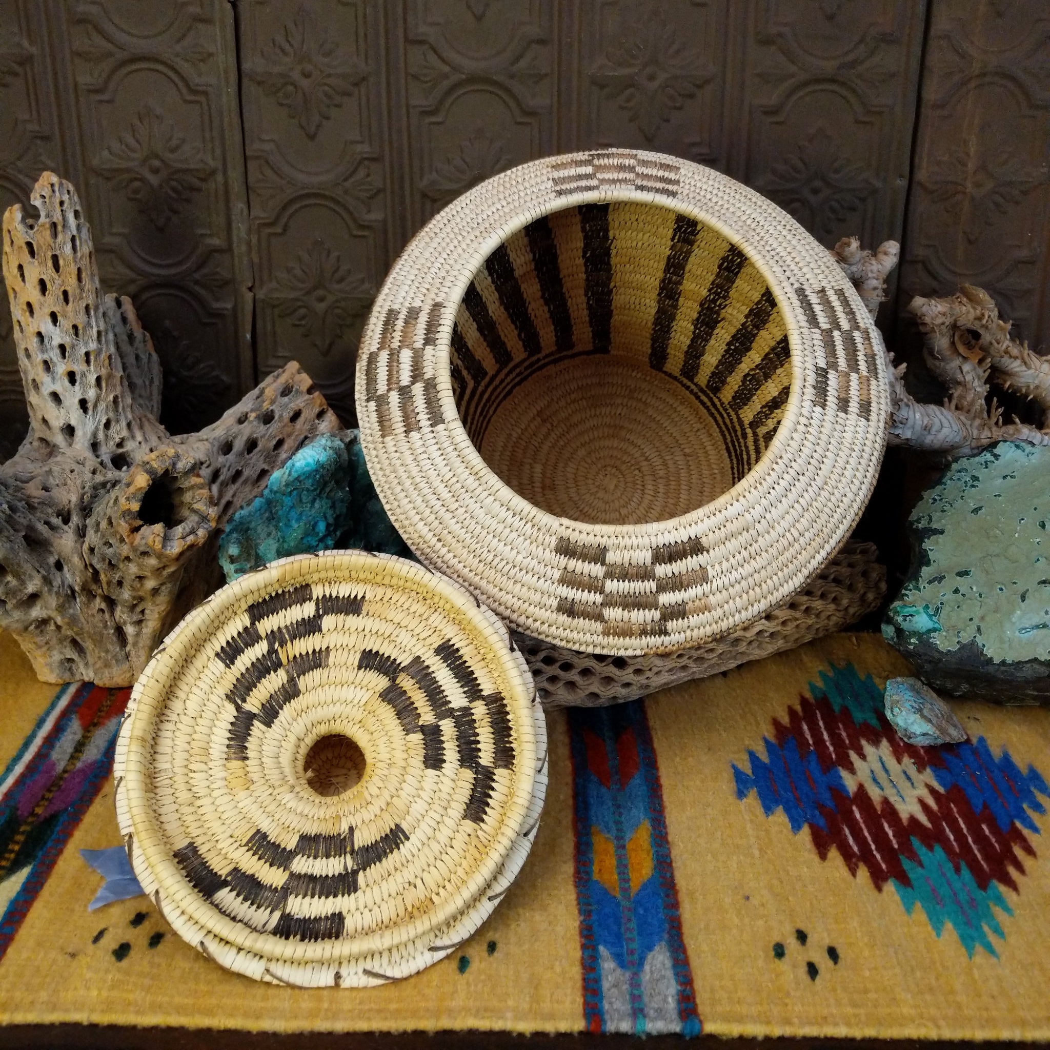 Award-winning Tohono O'odham handwoven lidded basket by Mary Thomas with geometric woven patterns in natural and dark fibers.