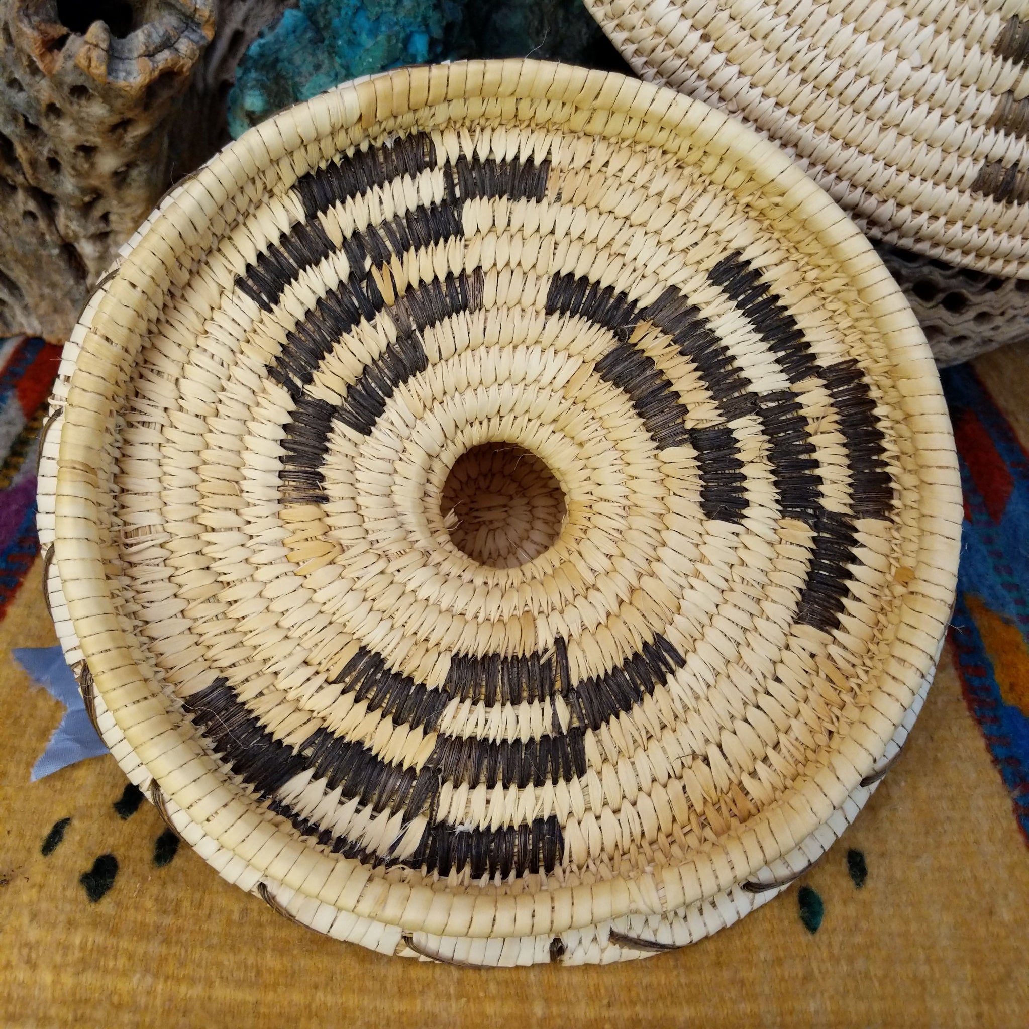 Award-winning Tohono O'odham handwoven lidded basket by Mary Thomas with geometric woven patterns in natural and dark fibers.