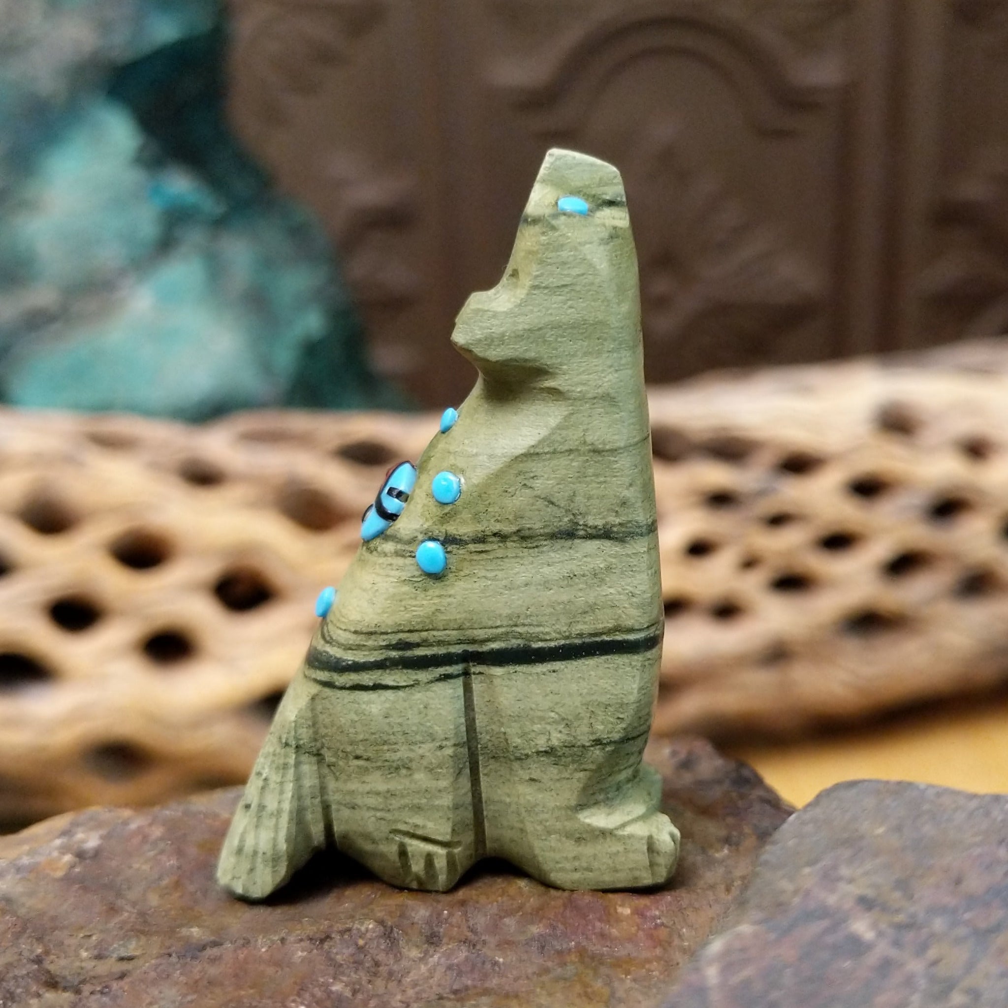 Wolf Zuni fetish carving by Danette Laate in green serpentine with turquoise inlay and a colorful medicine bundle.